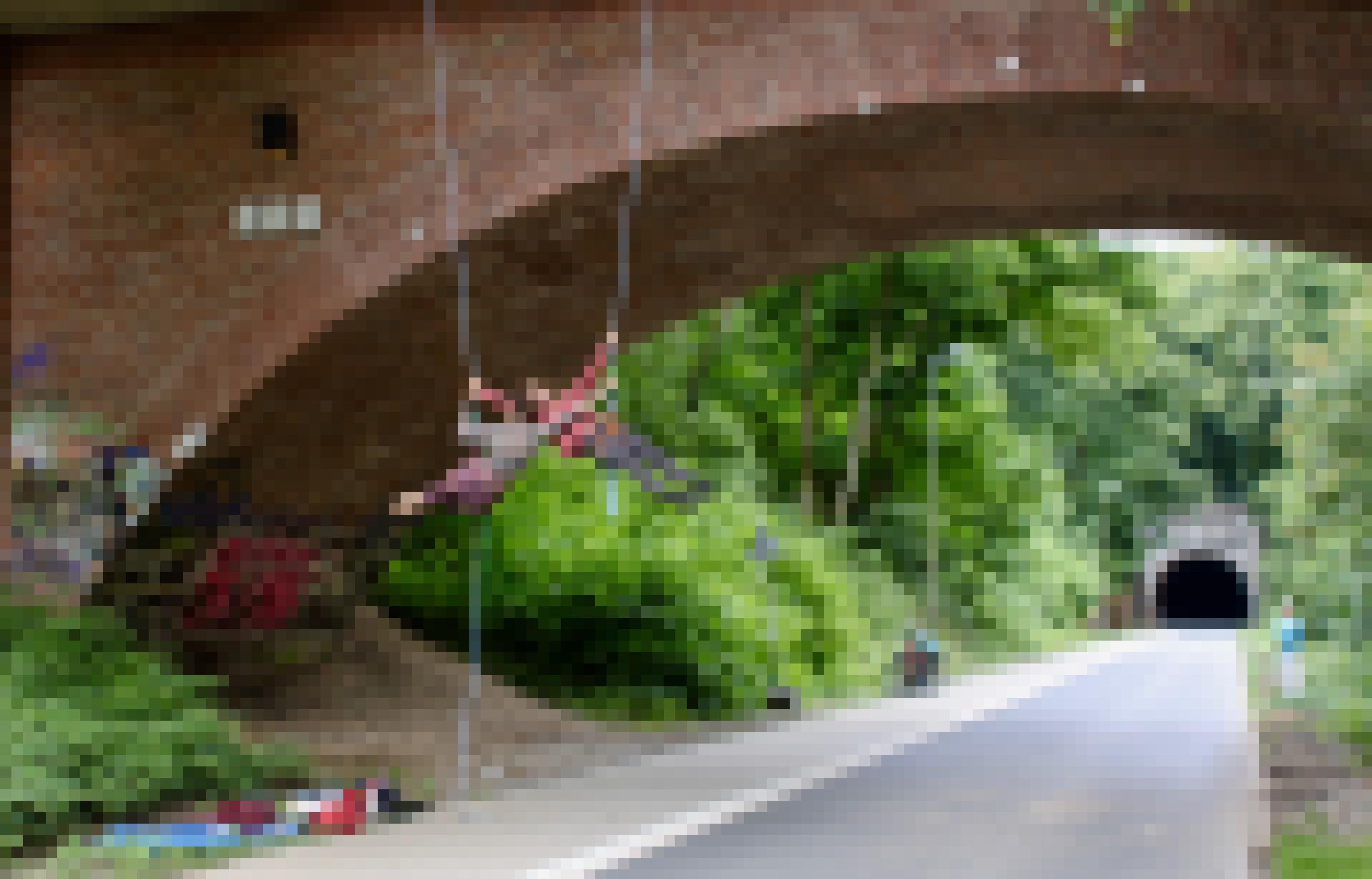 Zwei Menschen seilen sich an einer Brücke ab. Unter ihnen ist ein leerer Fußweg und ein schmaler Radweg.