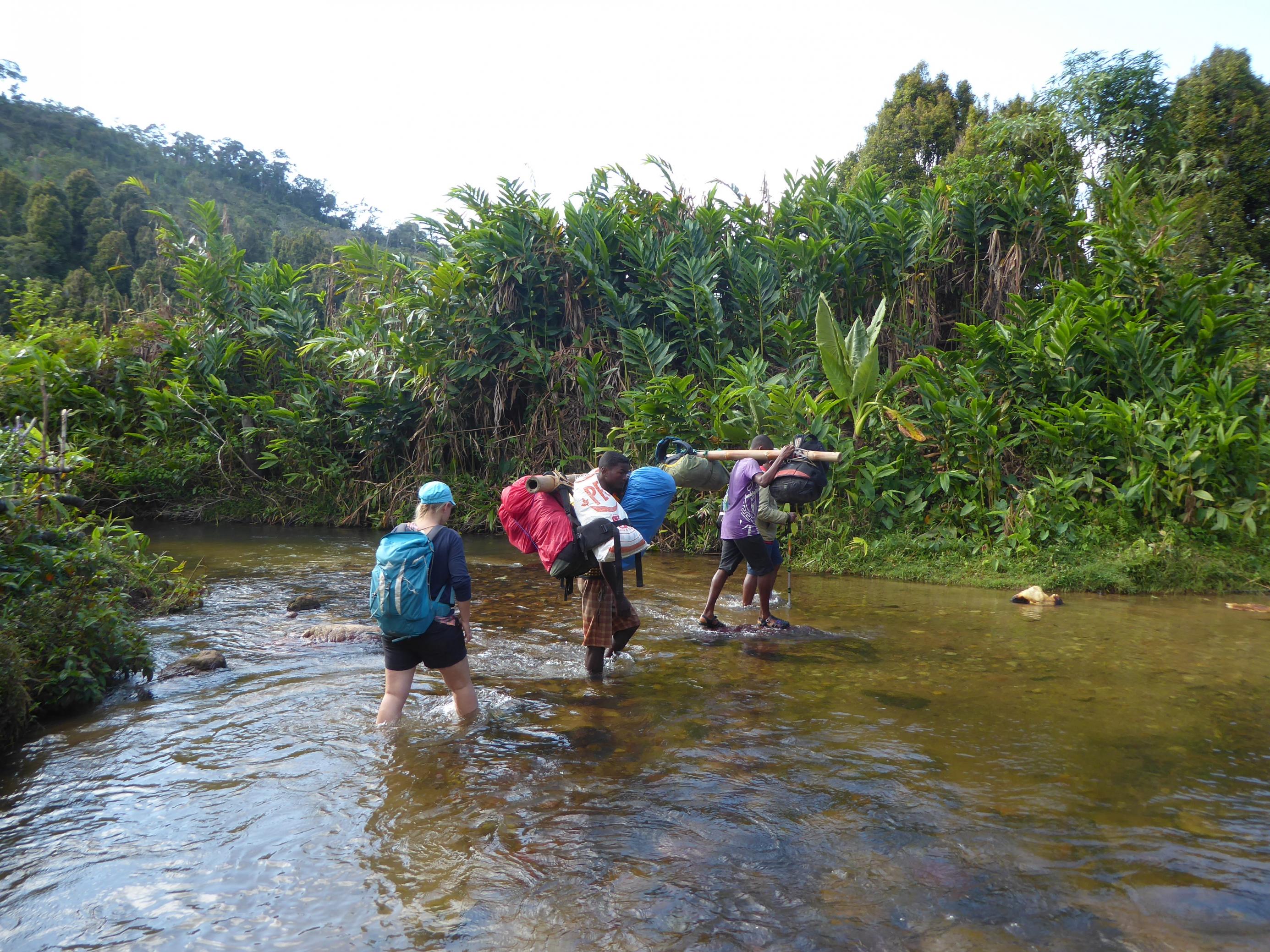 Julie Zähringer schreitet in Madagaskar durch einen Fluss und begleitet Einheimische. Die Forscherin der Universität Bern hat in Madagaskar erforscht, wie die örtliche Bevölkerung auf Änderungen der Landnutzung reagiert.