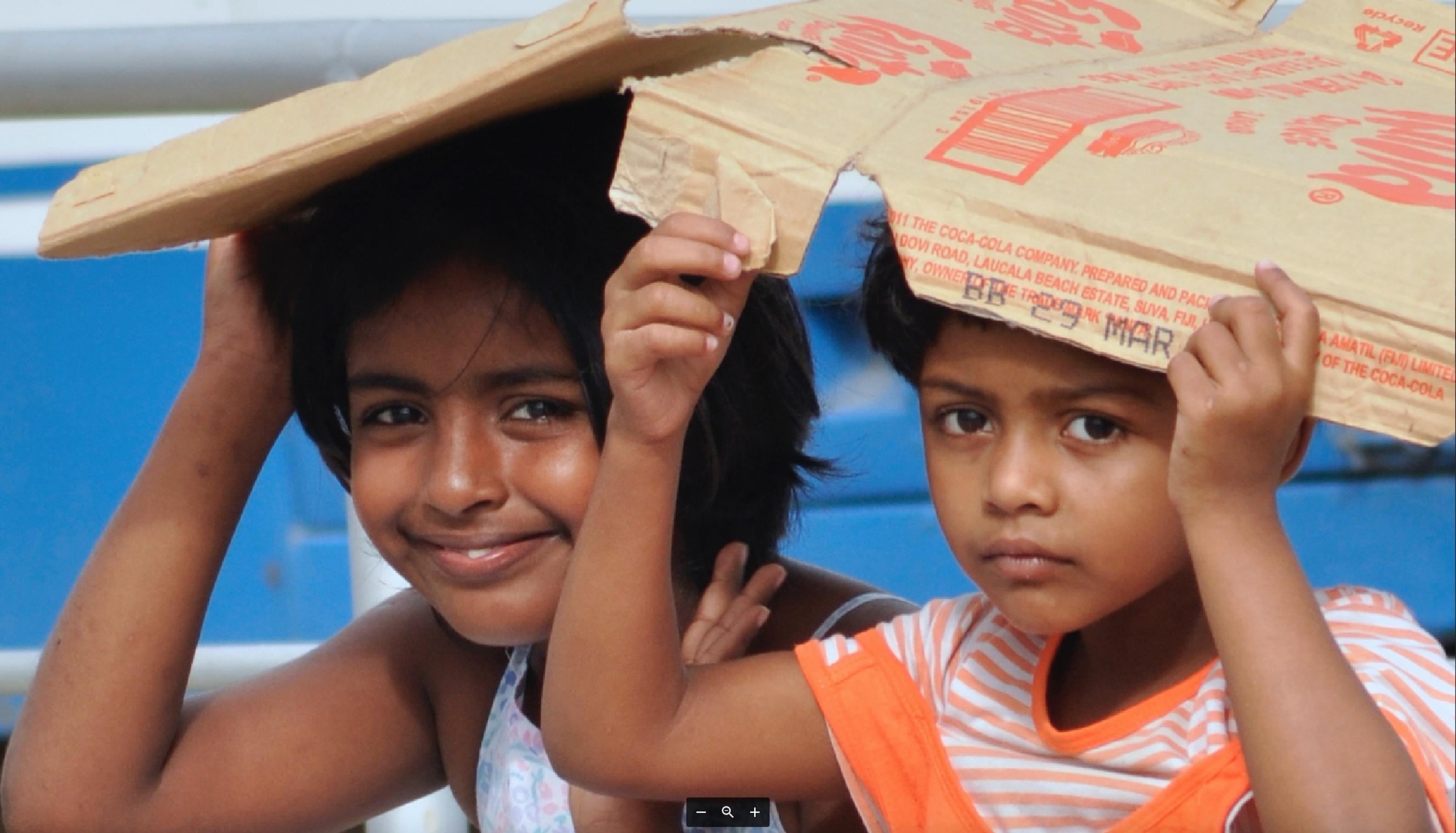 Bei Sonnenschein und wenn der Fotograf kommt, genügt eine Pappe als Schutz. Doch die Mädchen auf Fidschi werden in ihrem Leben vermutlich erleben, wie die Elemente ihre Inseln mit ständig wachsender Gewalt bedrängen.