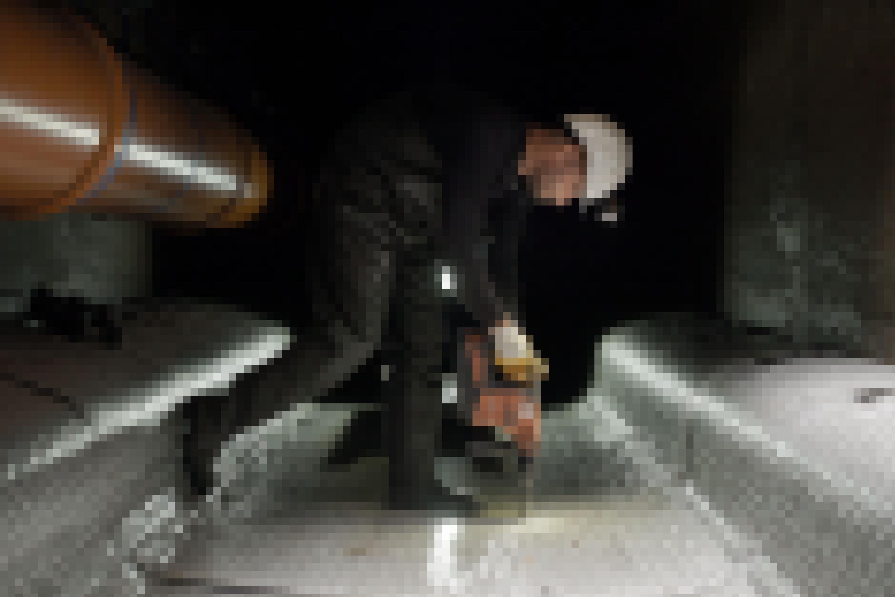 Ein Mann steht in einem dunklen Kanaltunnel, er schraubt am Boden eine Metallverschaltung fest.