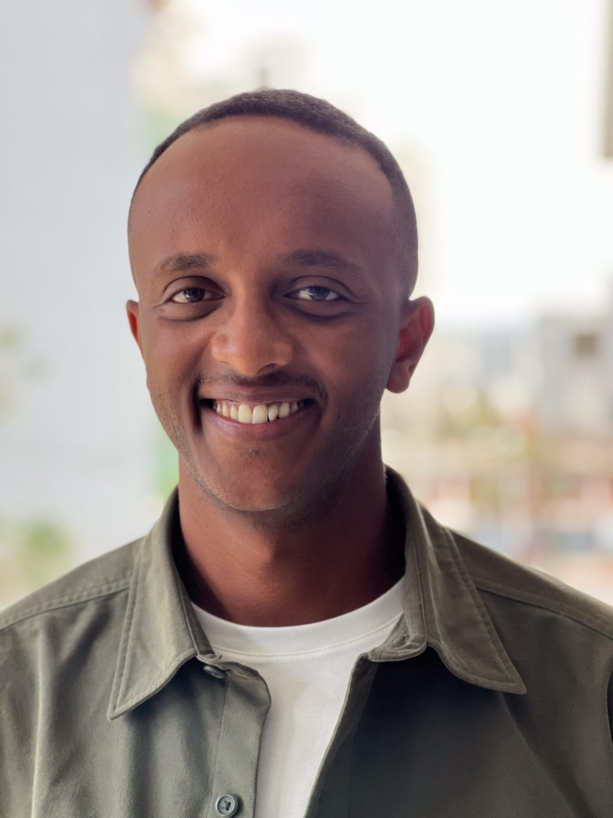 Ein Porträt, der Porträtierte lacht breit, offenes Gesicht. Ein relativ junger Mann - 37 Jahre alt.