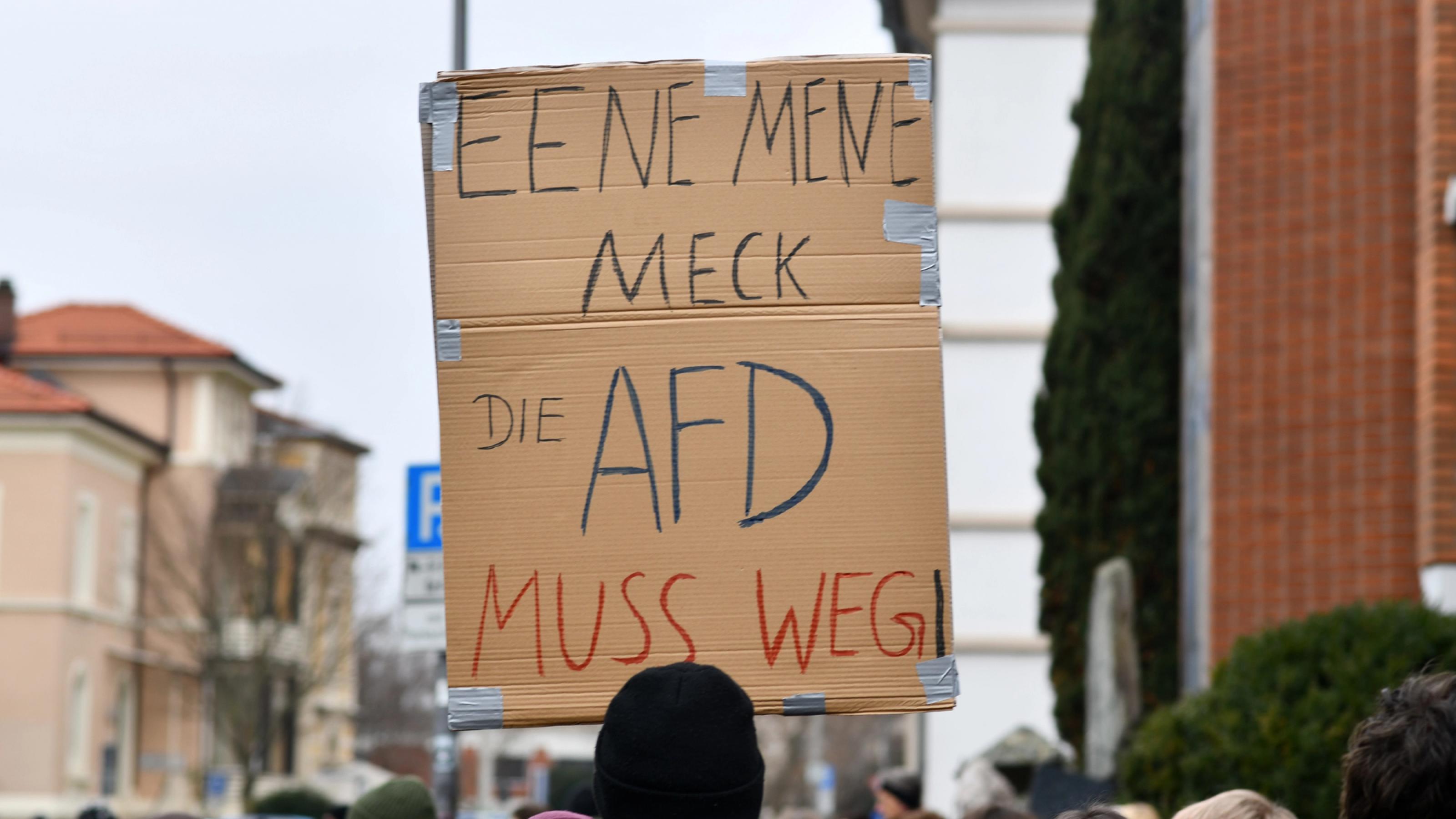 Ein Pappschild, das bei einer Demonstration gegen Rechtsextremismus hochgehalten wird, zeigt die Aufschrift: „Ene mene meck, die AfD muss weg!“