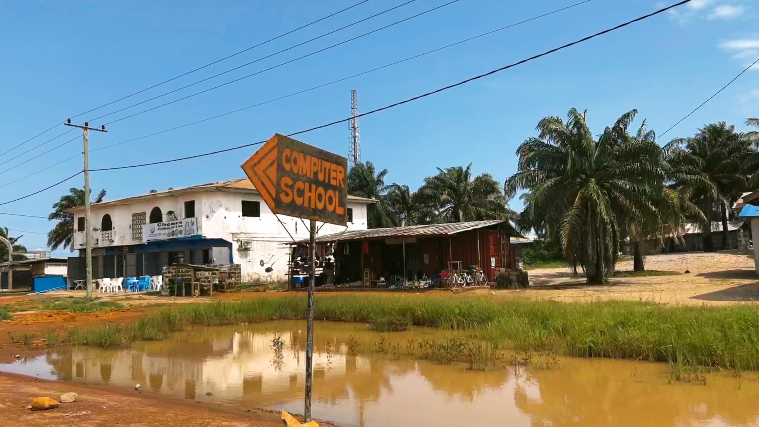 Ein Schild weist den Weg zu einer Computerschule im ländlichen Liberia, Westafrika.