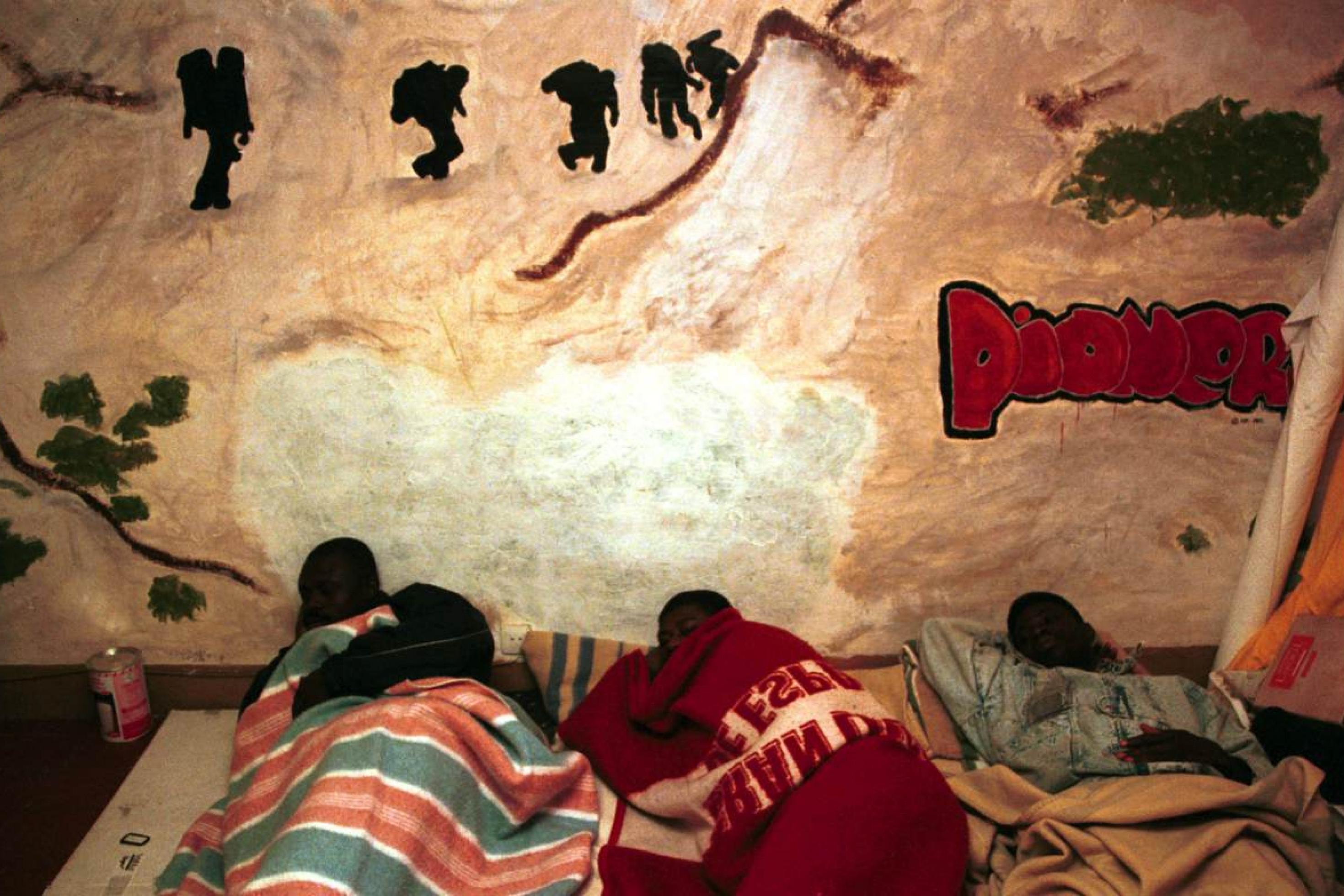 Migranten schlafen in einer als Unterkunft hergerichteten Wohnung in Barcelona am Boden.