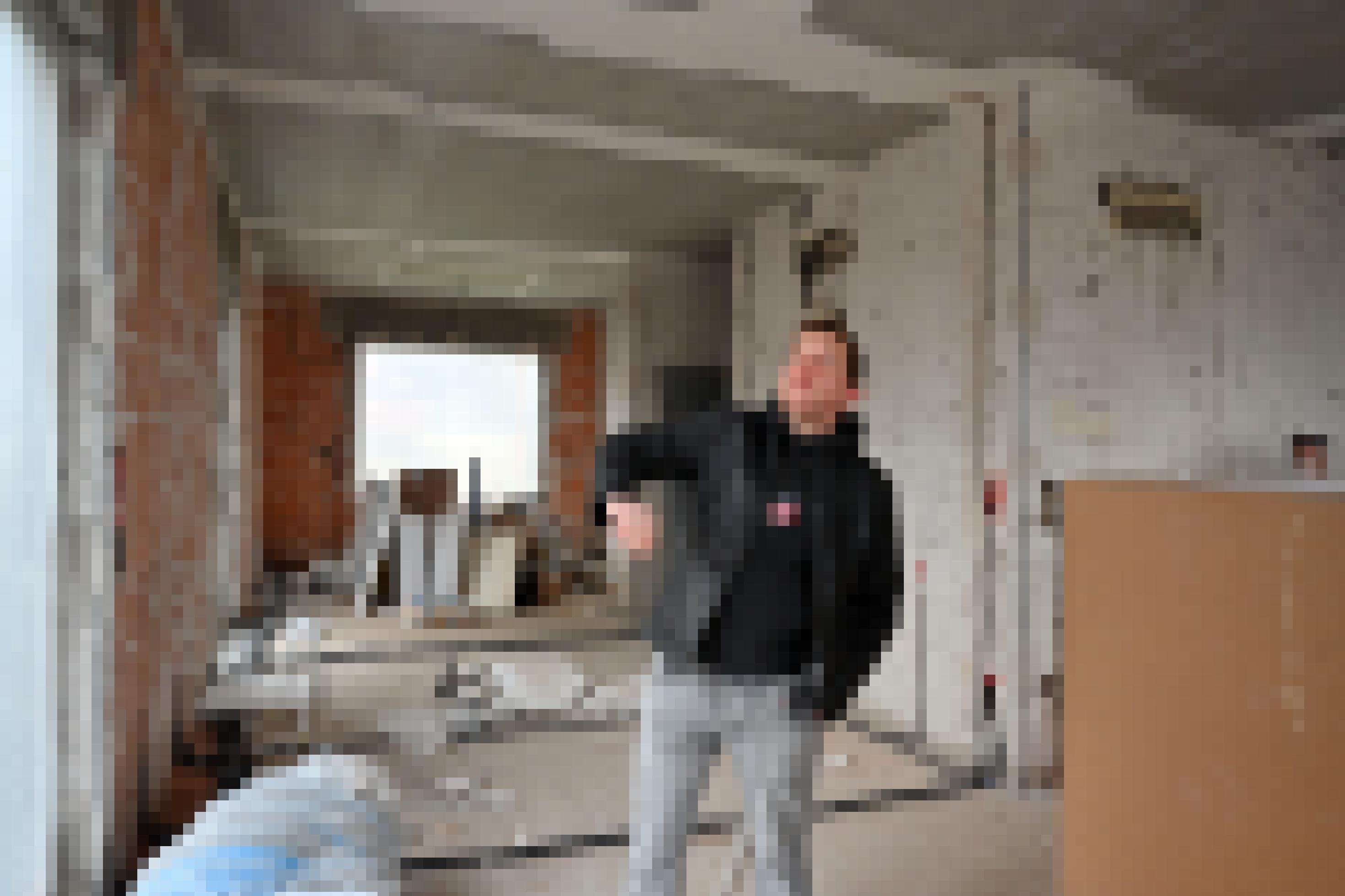 Ein Mann zeigt auf das entkernte Innere seines Hauses