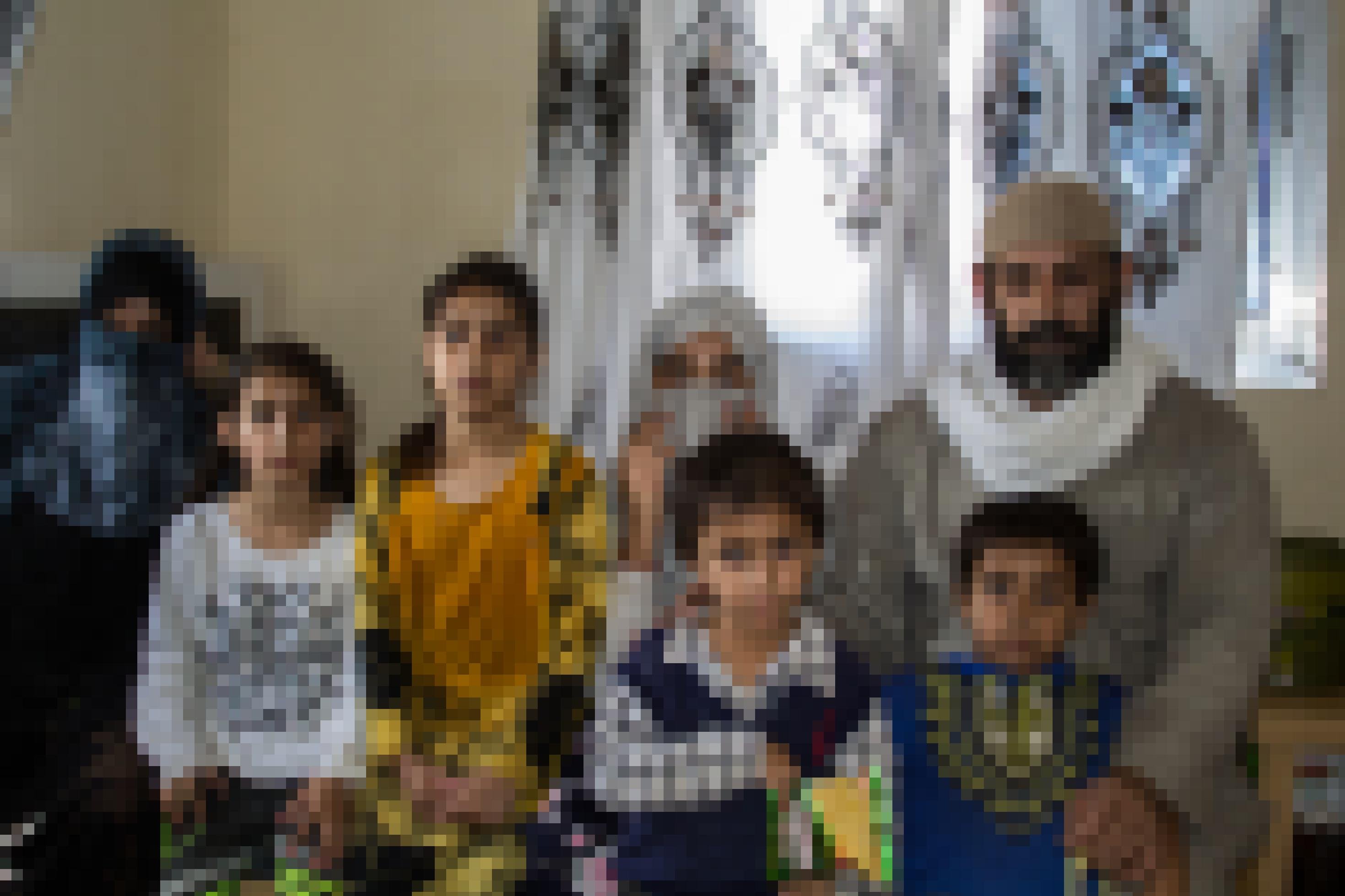 Vater, Mutter und fünf Kinder drängen sich für das Foto auf einem Bett zusammen. Die Mutter ist verschleiert. Es vermittelt sich der Eindruck, dass die Familie in recht beengten Verhältnissen wohnt.