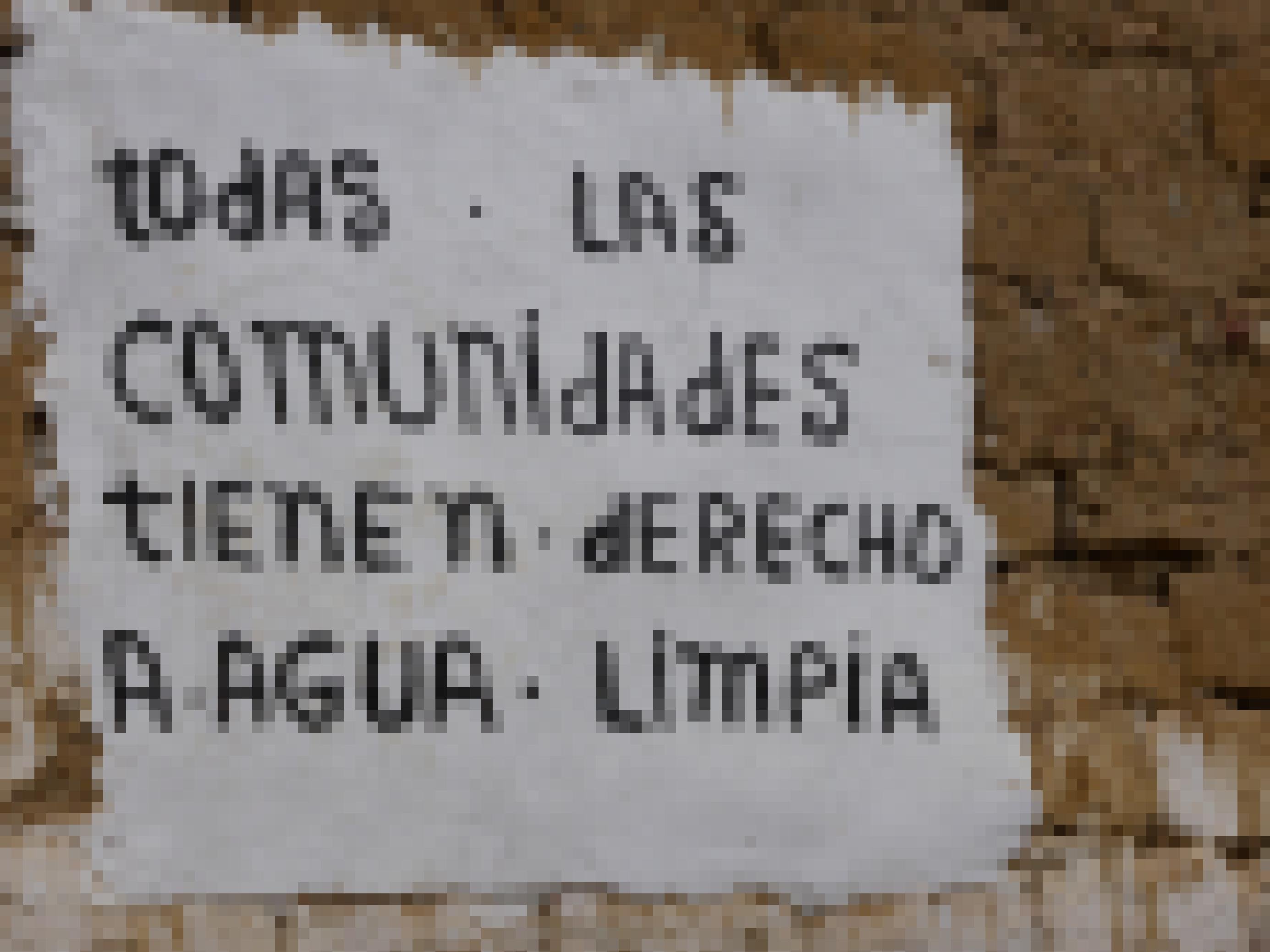 Lehmziegelmauer ist beschriftet mit einem weissen Kasten und folgender Botschaft: „Alle Gemeinden haben das Recht auf sauberes Wasser“"