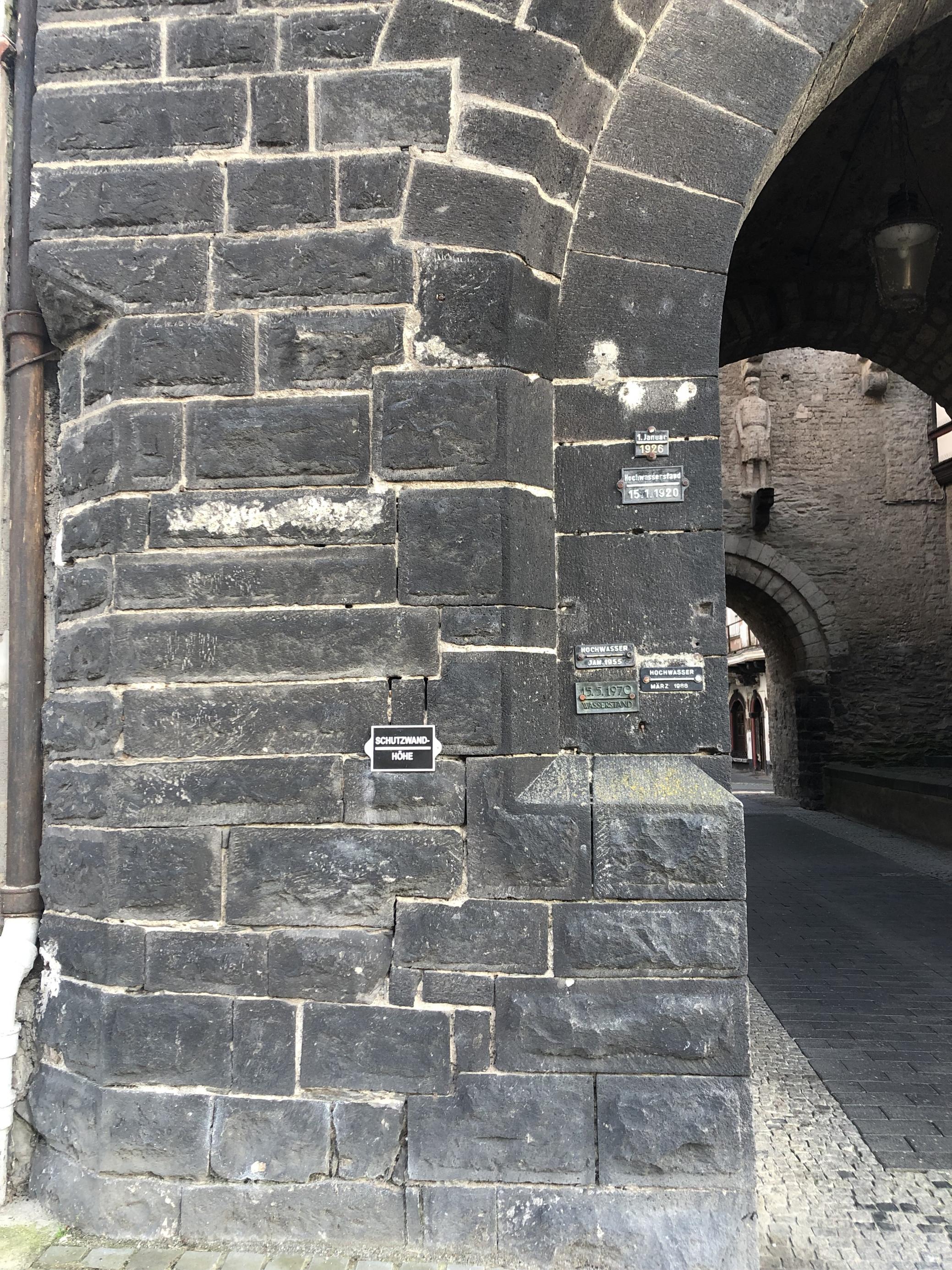 Die Hochwassermarken am alten Stadttor in Andernach am Mittelrhein zeigen, dass fünf Hochwasser-Ereignisse im 20. Jahrhundert die Höhe der Schutzmauer weit übertrafen. Die Höhe der Schutzmauer ist am Stadttor ebenfalls vermerkt.