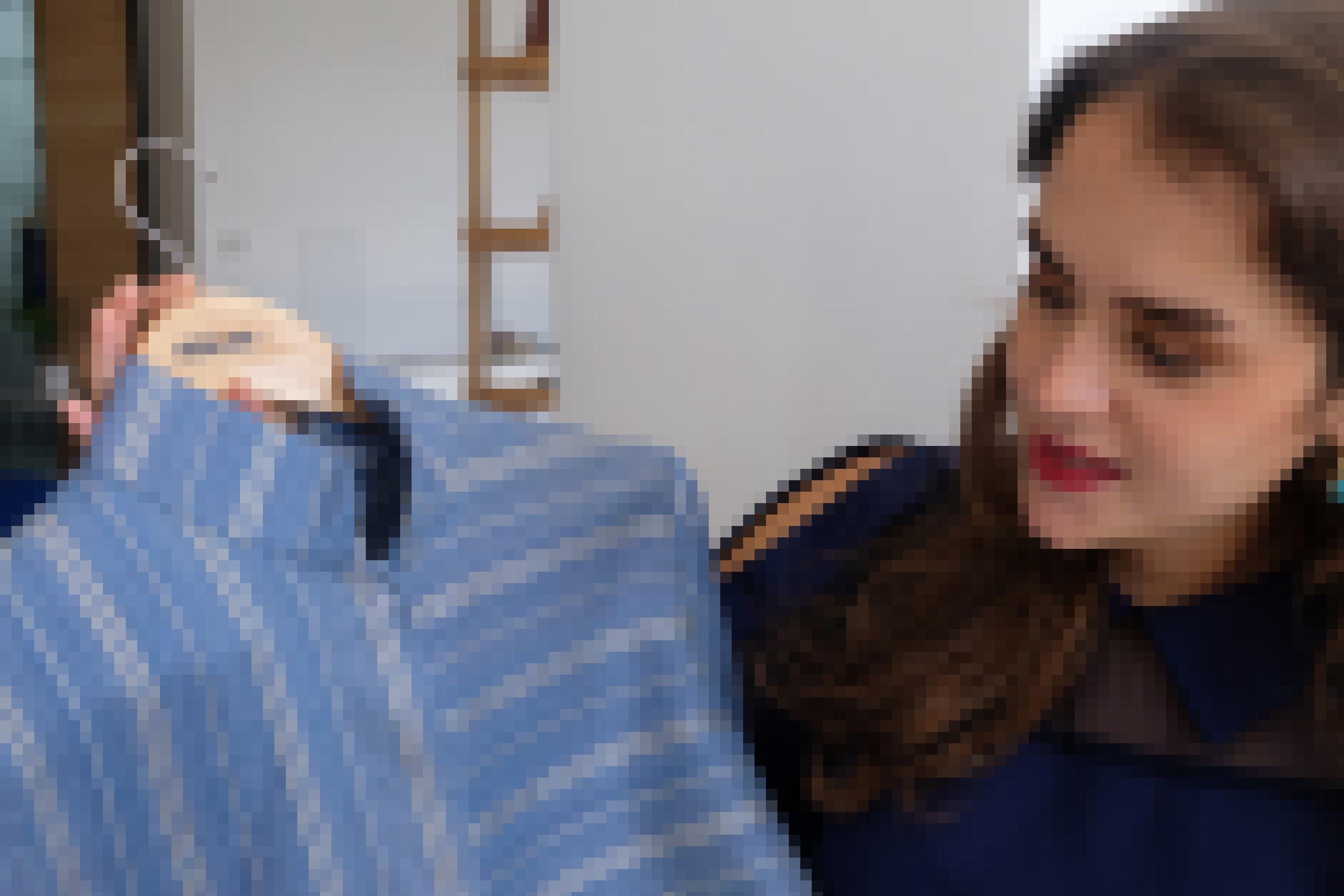 Anissa Meddeb hält ein hellblaues, gestreiftes Seidenhemd in der Hand