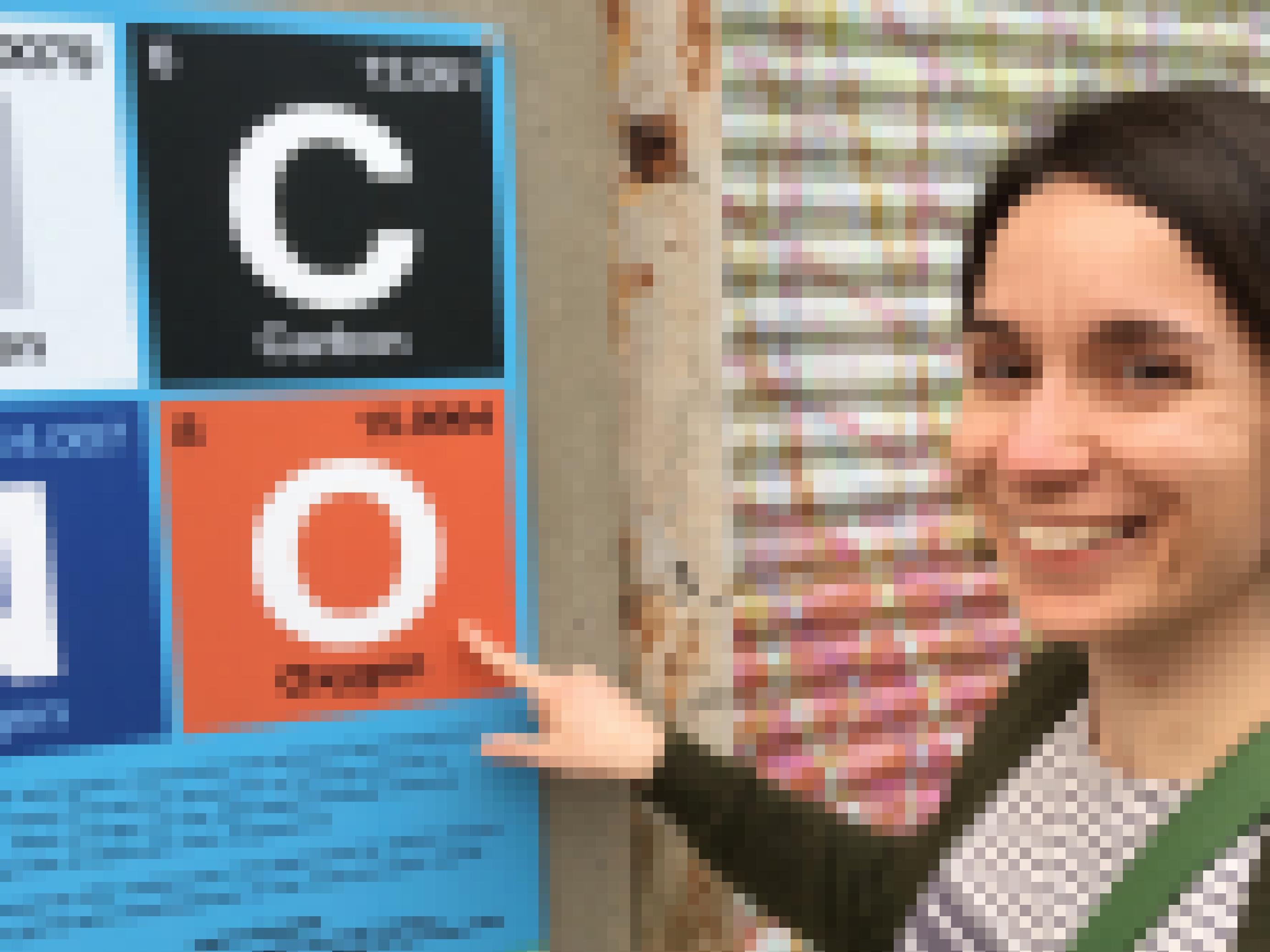 Anja Krieger steht vor einem Schild auf der ein paar Elemente des Periodensystems stehen. Sie zeigt auf Oxygen (Sauerstoff)