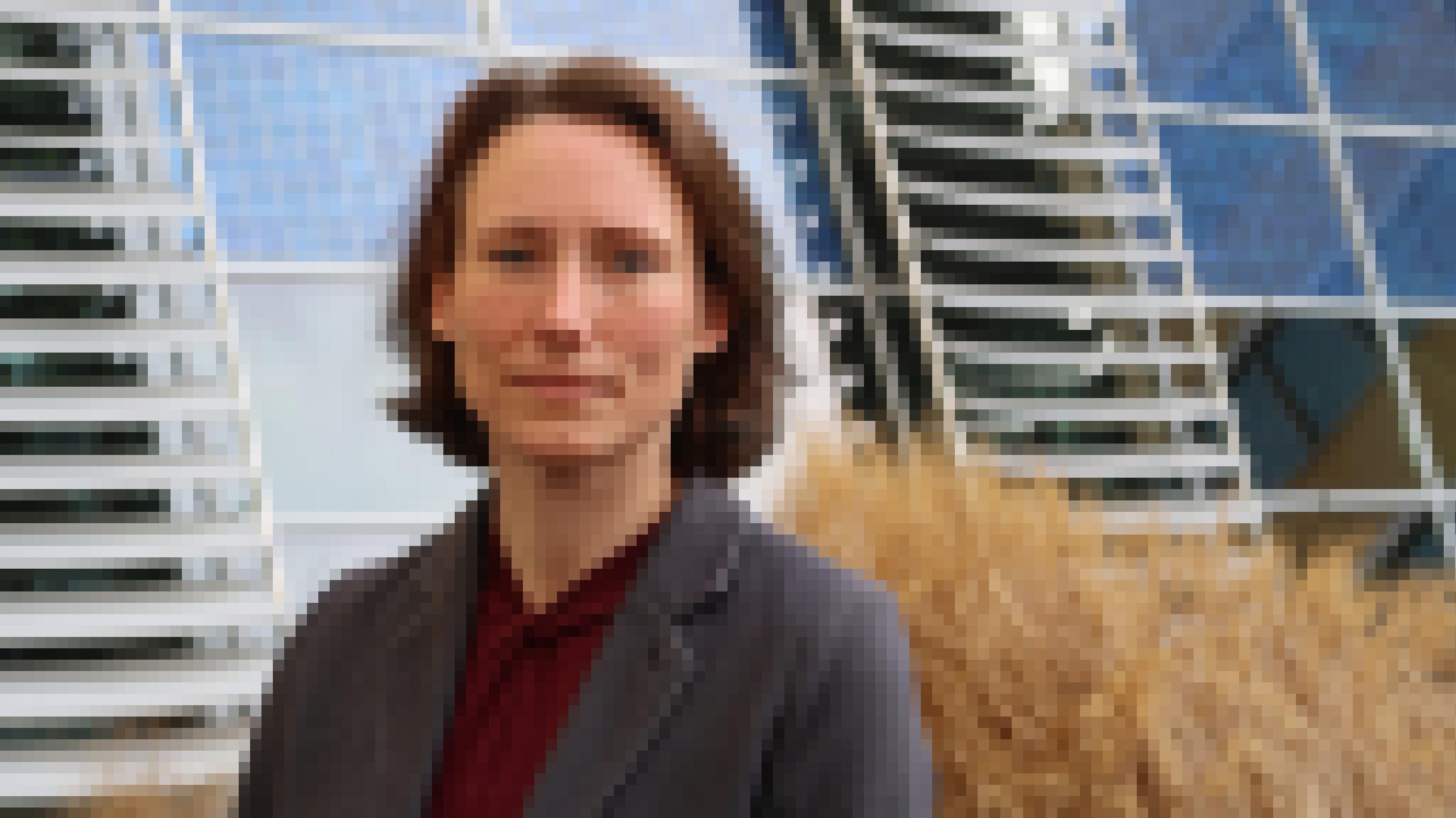 Energie-Expertin Anke Weidlich im Innenhof ihres Instituts. Im Hintergrund sind PV-Module zu sehen, die Strom erzeugen