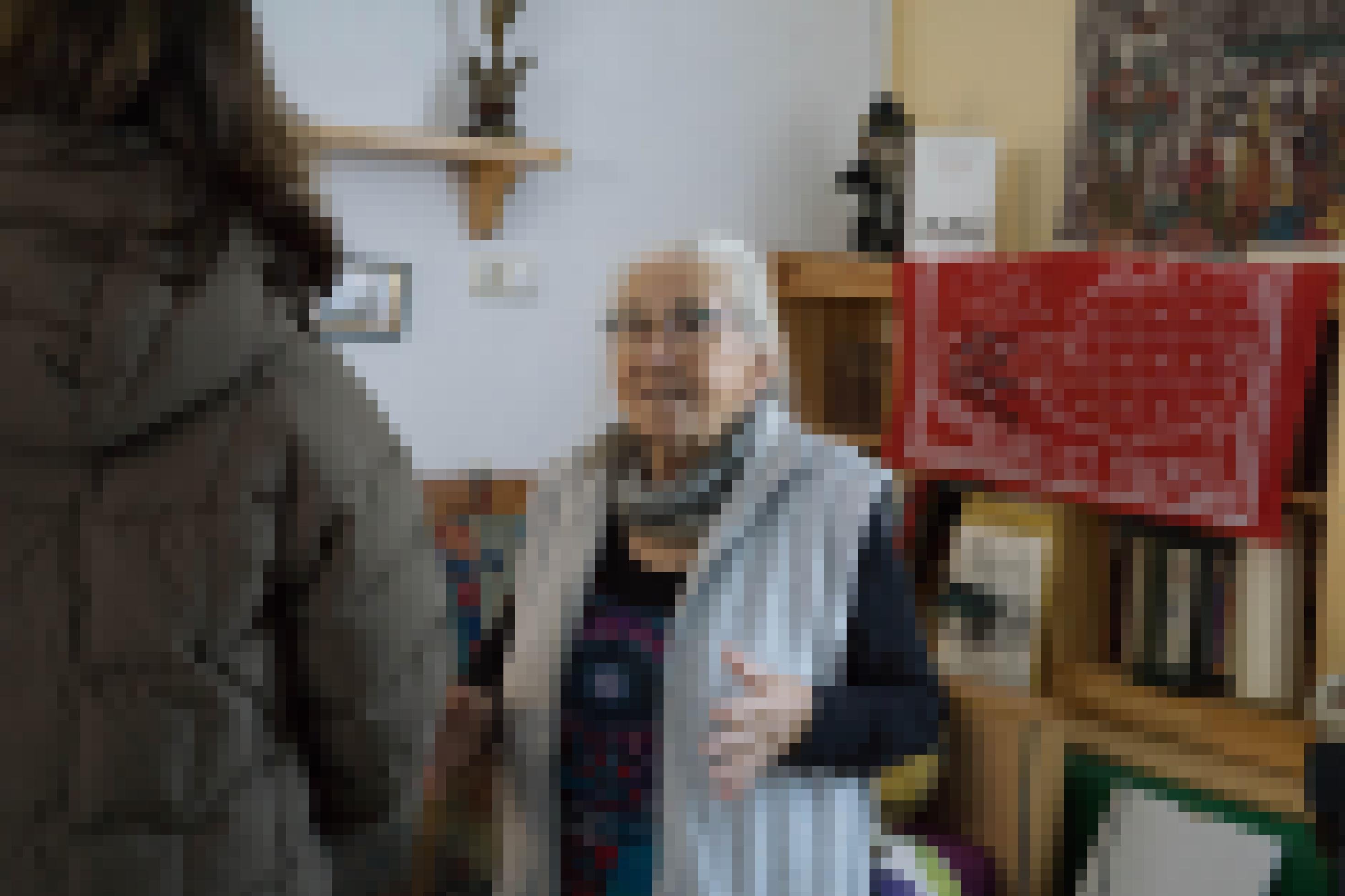 Ältere Frau in einem Zimmer mit Erinnerungsstücken an die Aubesetzung.