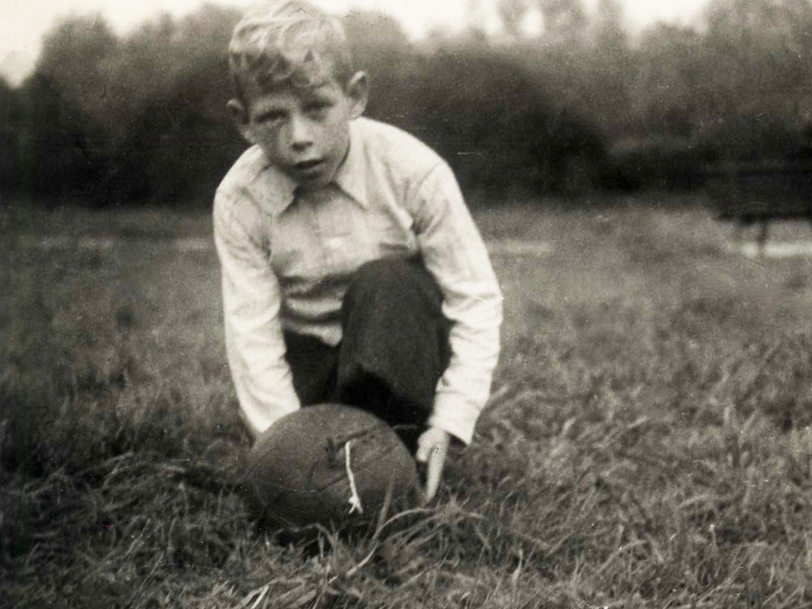Kinderfoto von Paul Crutzen. Er kniet auf der Wiese. Vor ihm liegt ein Fußball.