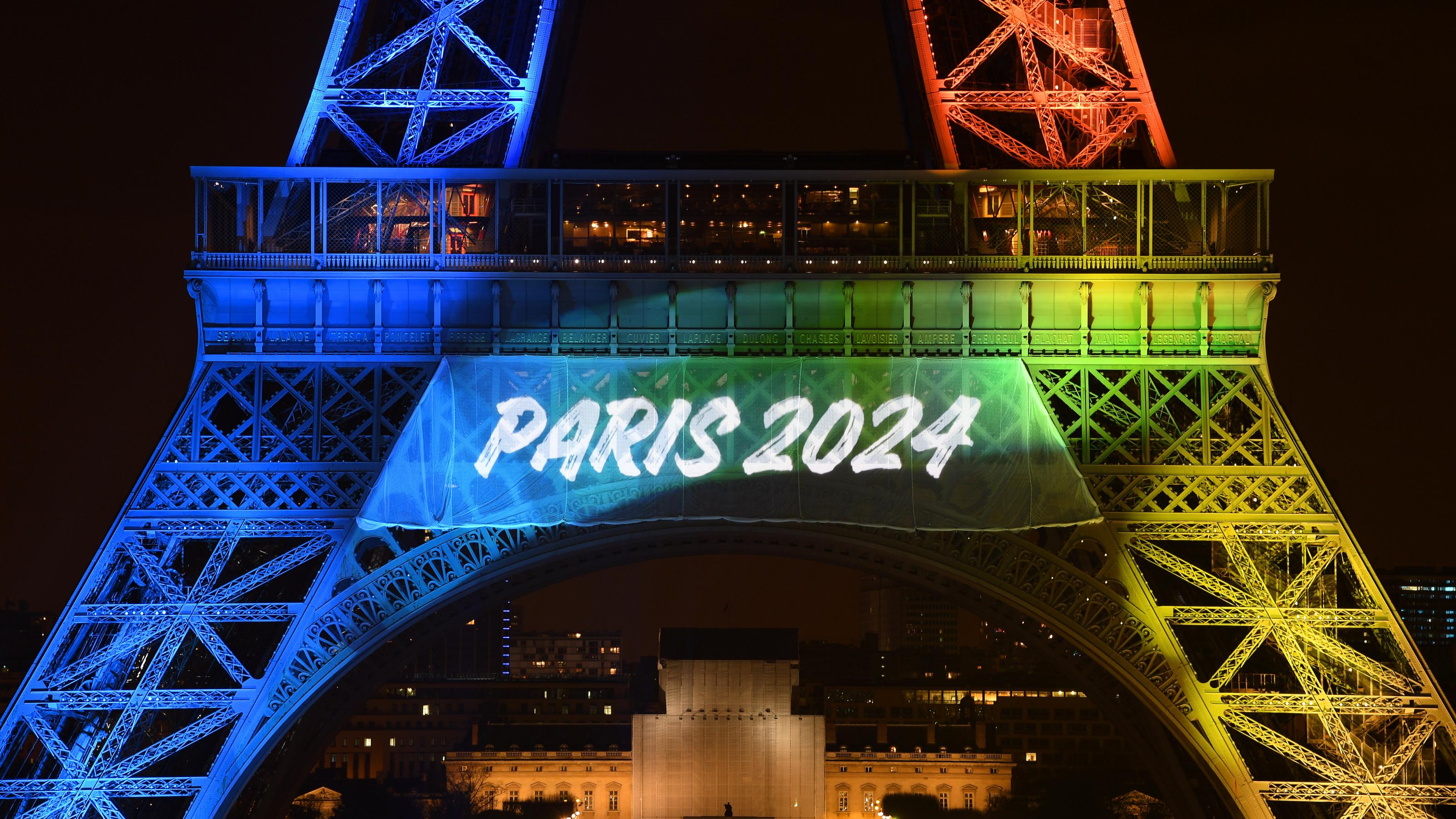 Hellerleuchteter Eiffelturm mit der Beschriftung „Paris 2024“