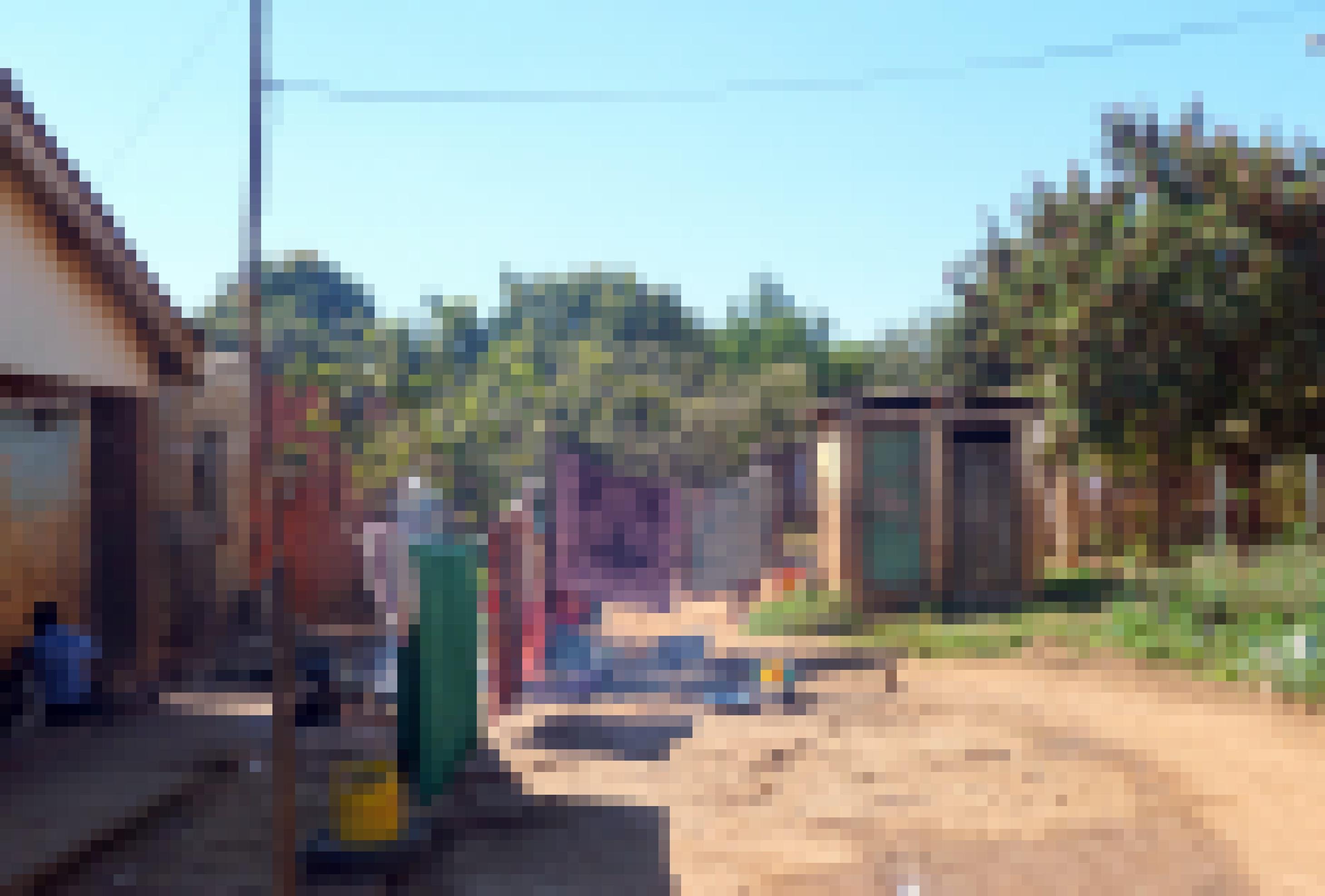 Das Bild zeigt ein kleines Haus mit Klohaeuschen und Waescheleine in einem Armenviertel in Simbabwe. Die Armut ist unuebersehbar.