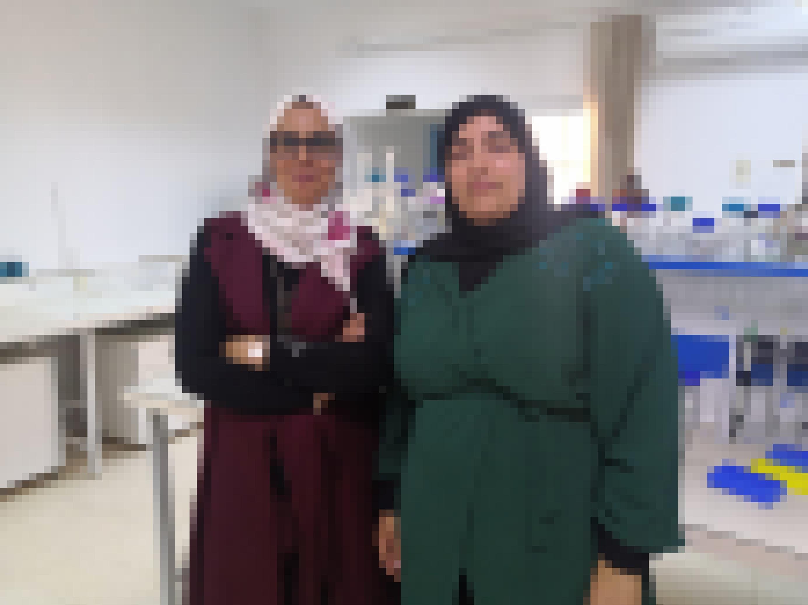 Zwei Frauen stehen in einem Labor und blicken lächelnd in die Kamera
