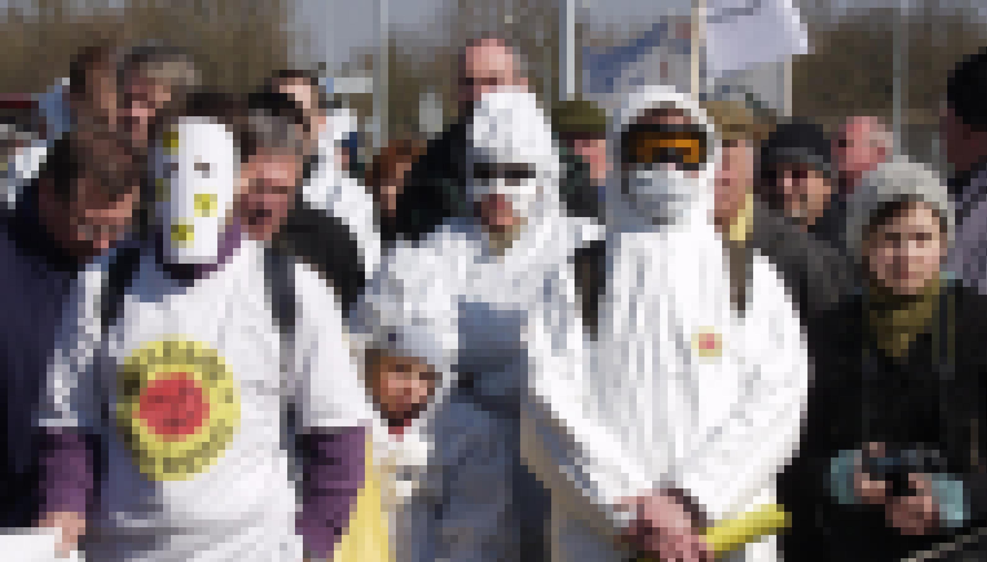 In weiße Overalls gekleidete Demonstrierende protestieren gegen Atomkraft