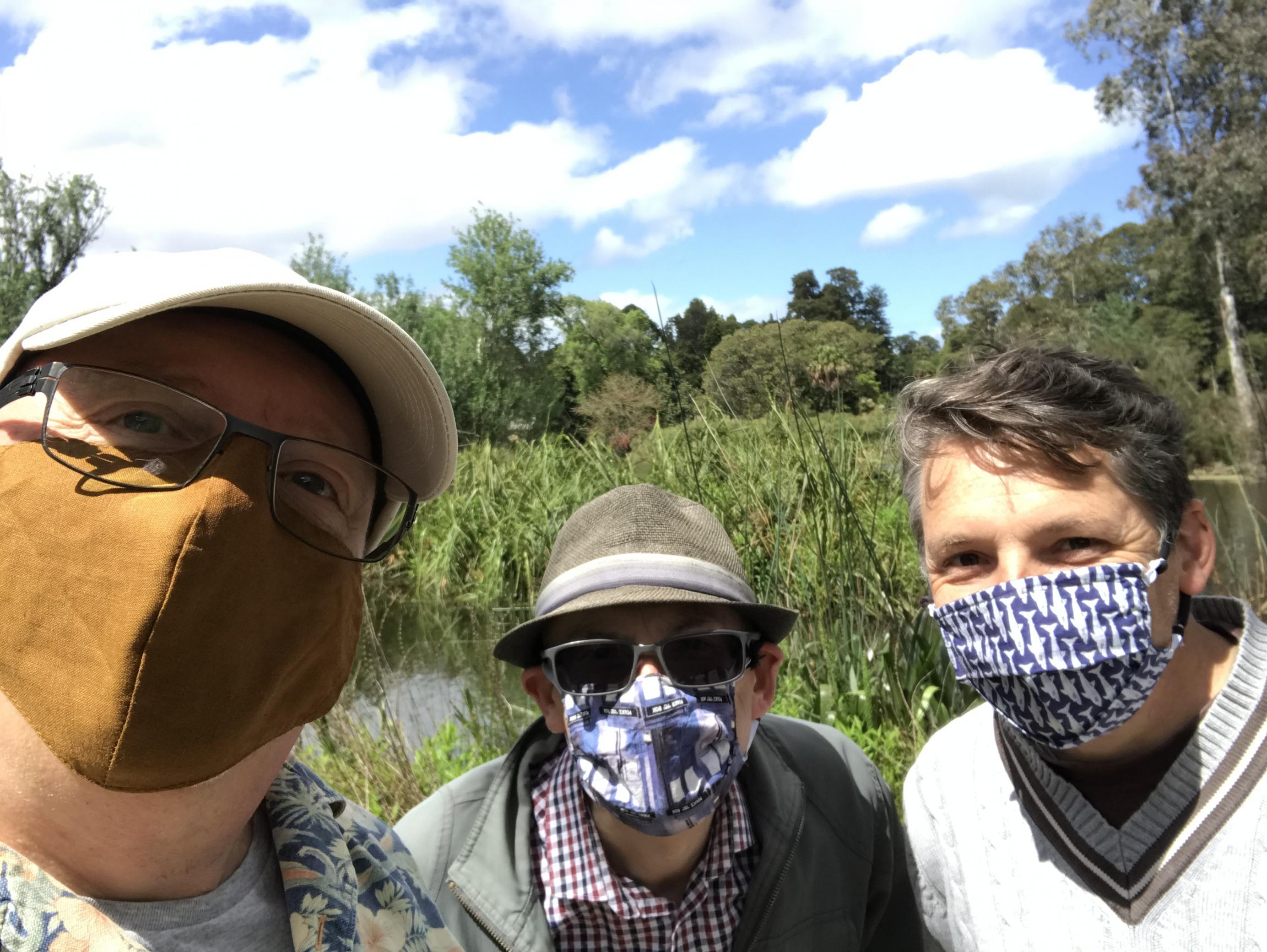 Der Lehrer Drew Stocker mit zwei Freunden –  alle tragen eine Maske – währeend eines Ausflugs zwischen den Lockdowns im Botanischen Garten in Melbourne.
