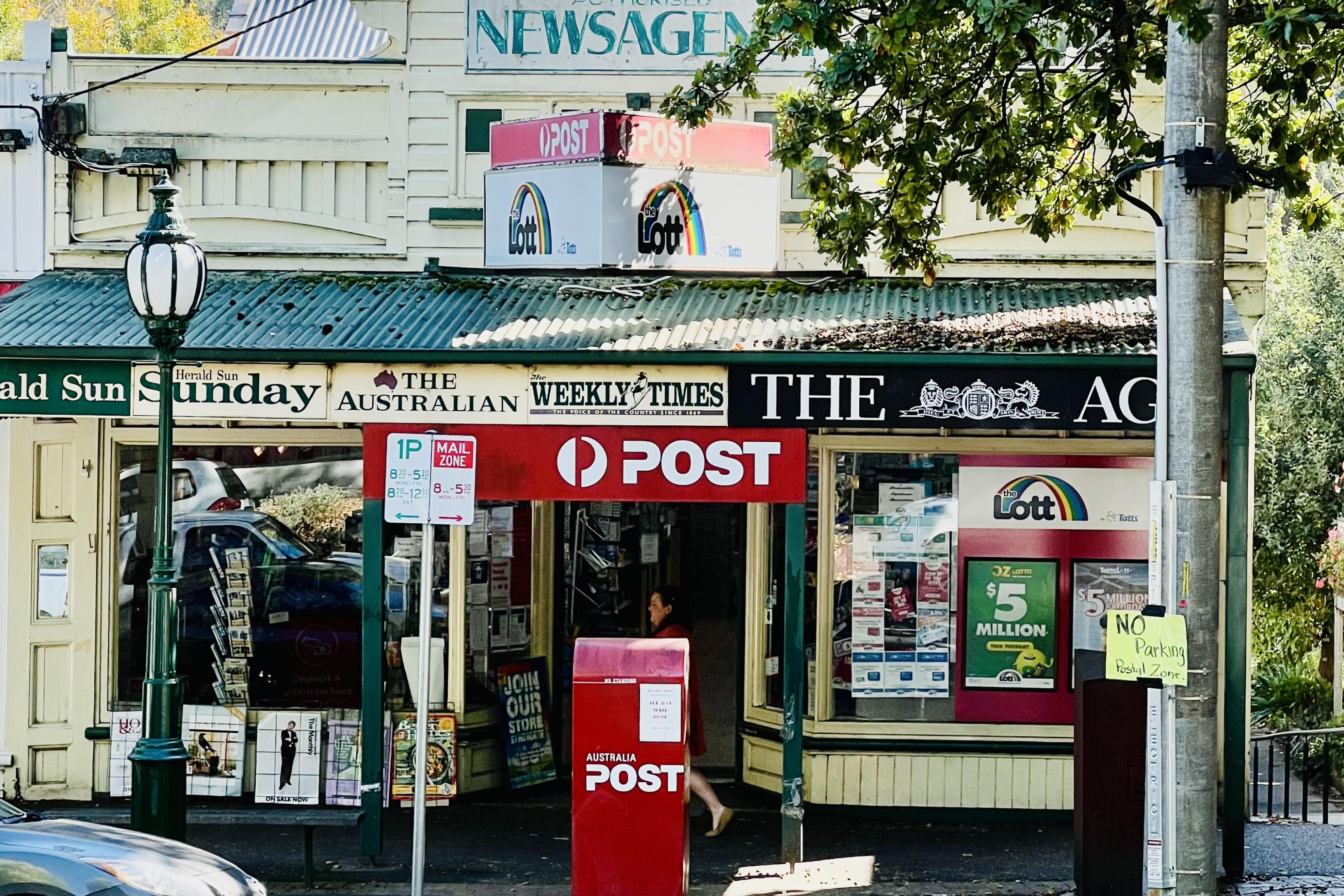 Ein Schreibwarengeschäft in Healesville, Victoria, das gleichzeitig die Post des Ortes ist mit einem roten Briefkasten auf der Straße.