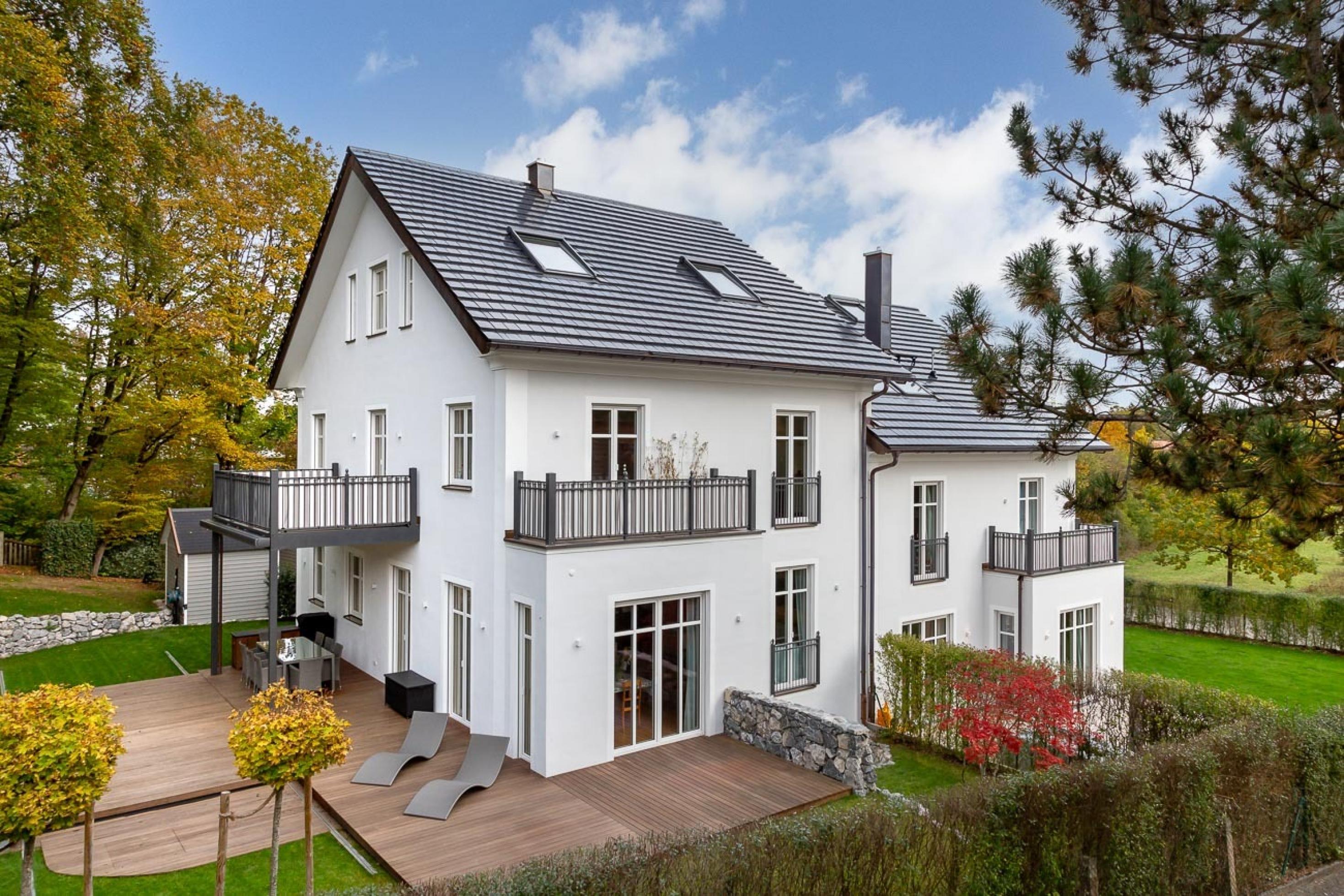 Ein Einfamilienhaus. Auf dem Dach liegen Solardachziegel, die aber aussehen wie normale Dachziegel.