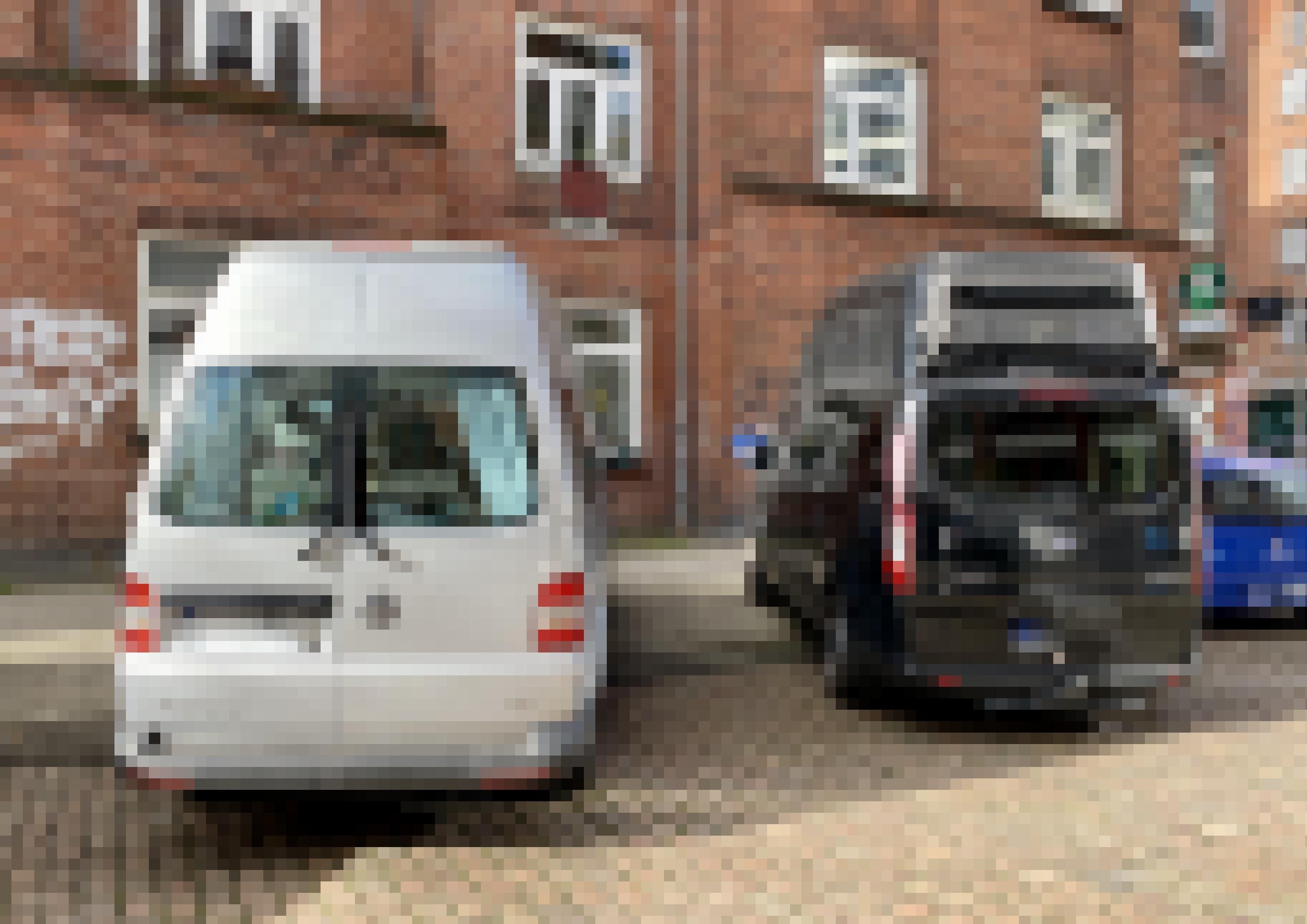 Zwei Wohnmobile mit Aufsatz parken vor einem Wohnhaus