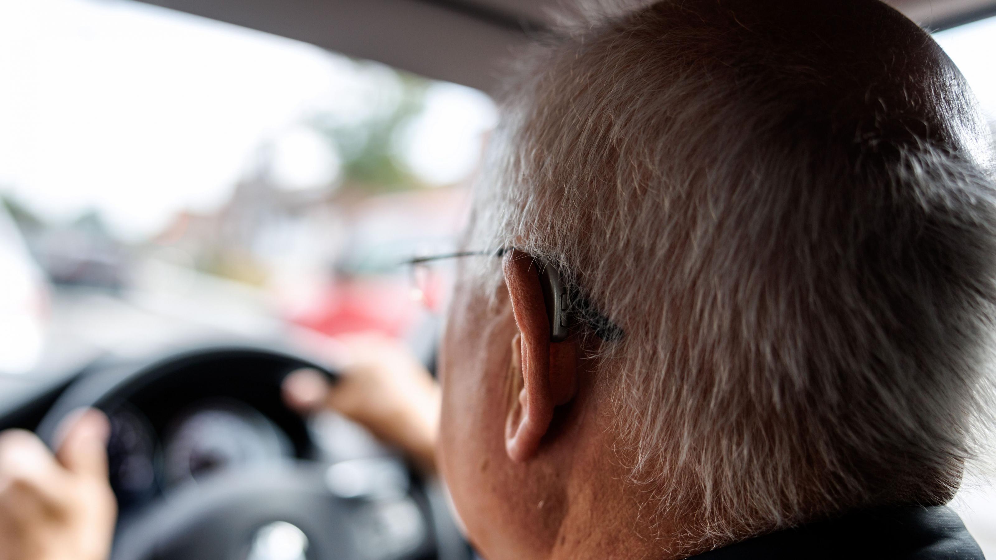 Ein alter Mann sitzt am Steuer eines Autos. Mit einer Demenzerkrankung verlieren die Menschen auf kurz oder lang die Fähigkeit, Auto zu fahren.