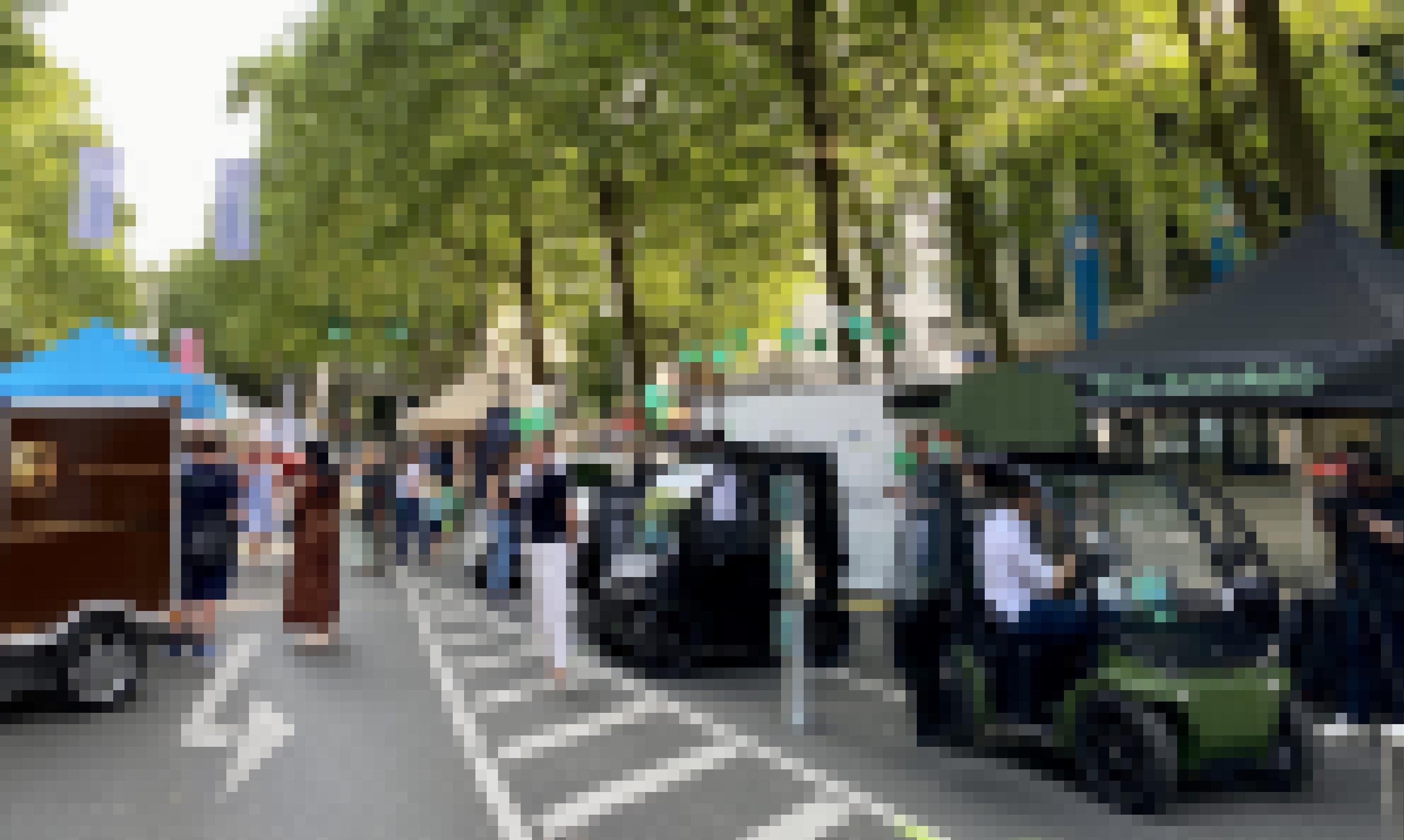 Während einer Messe stehen verschiedene kleine Elektrofahrzeuge in einer Reihe auf einer Straße