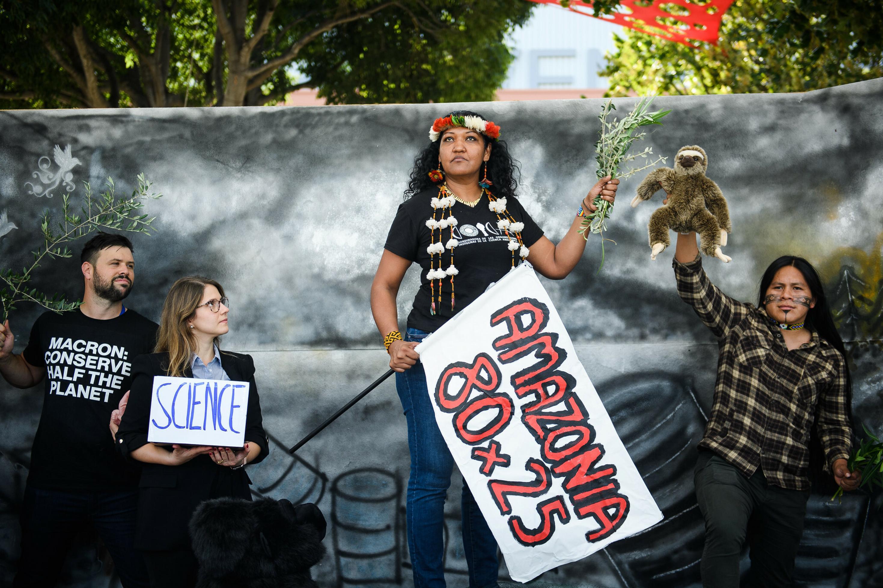 Die indigene Führerin Claudette Labonté aus französisch Guiana  hält ein Plakat mit der Forderung „Amazonia 80×25“ in der rechten Hand.
