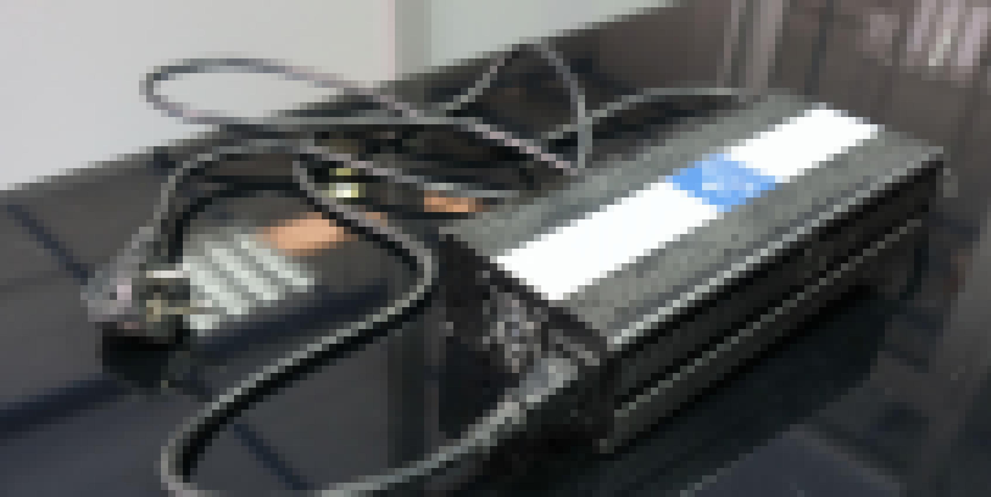 Auf einem Tisch liegt ein Ladegerät, dass an alte, etwas klobige Ladegeräte von Laptops erinnert.
