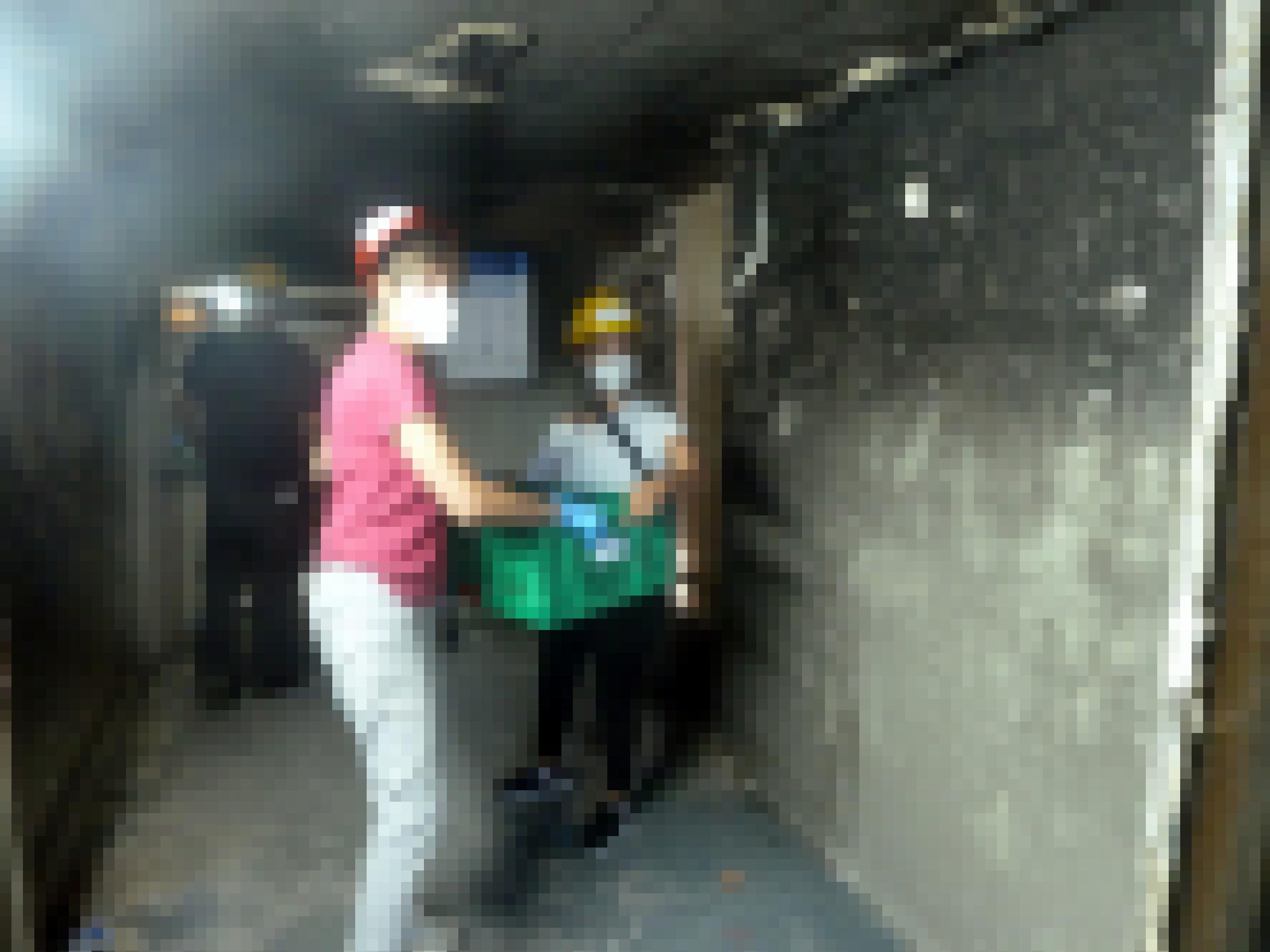 Eine Frau reicht einer anderen eine Kiste mit Archivmaterial, die Wände sind vom Feuer verrusst