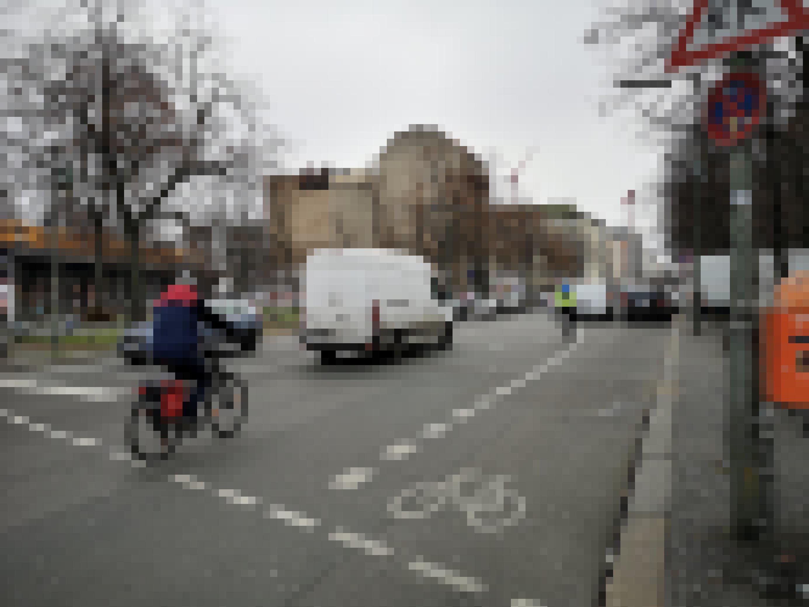 Autos versperren die Radspur. Die Radfahrer fädeln sich in den Autoverkehr ein