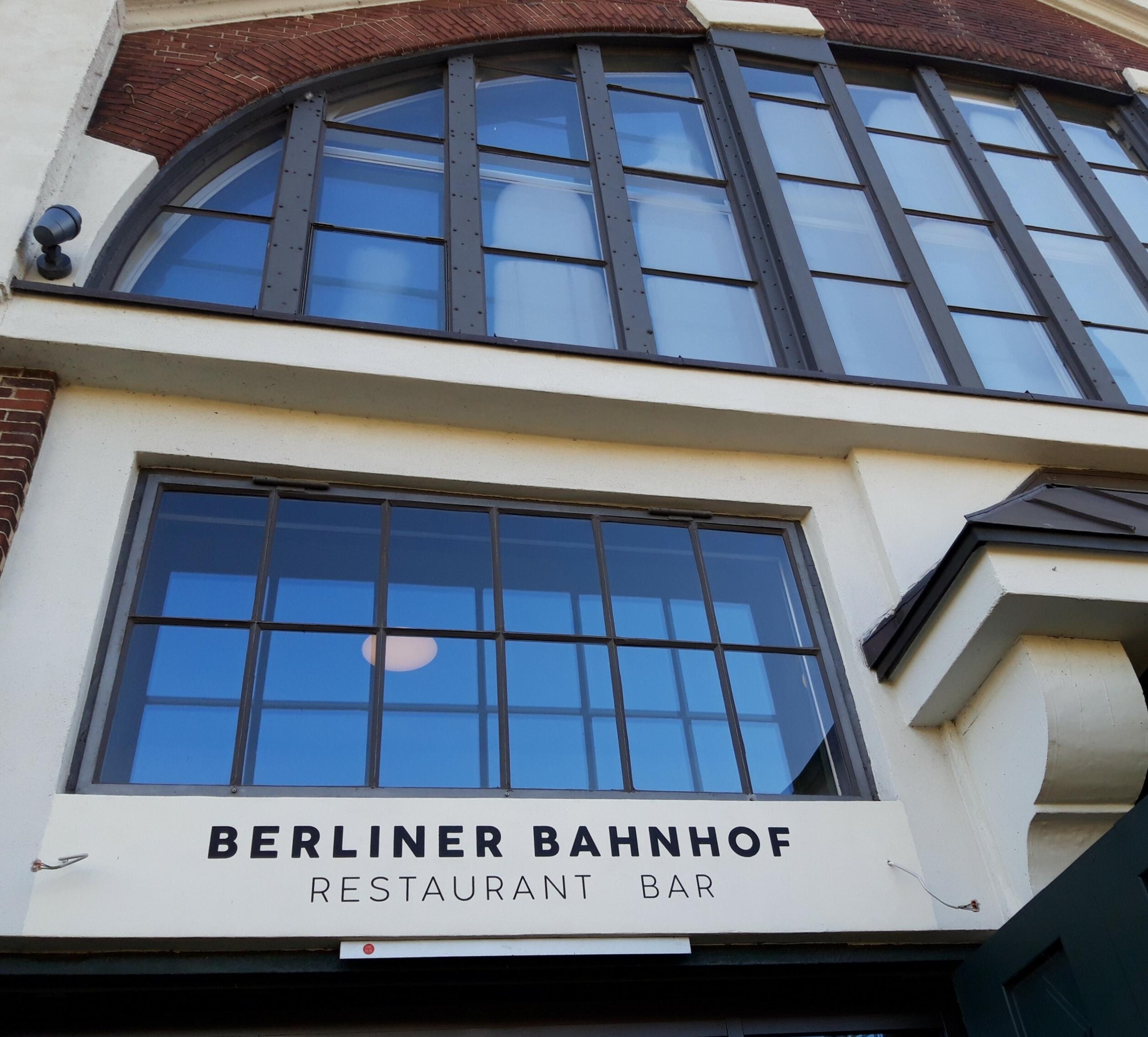 Zwischen einem großen, zuoberst angeordneten Halbrundfenster und einem Rechteckfenster prangen die Lettern „Berliner Bahnhof – Restaurant, Bar“.