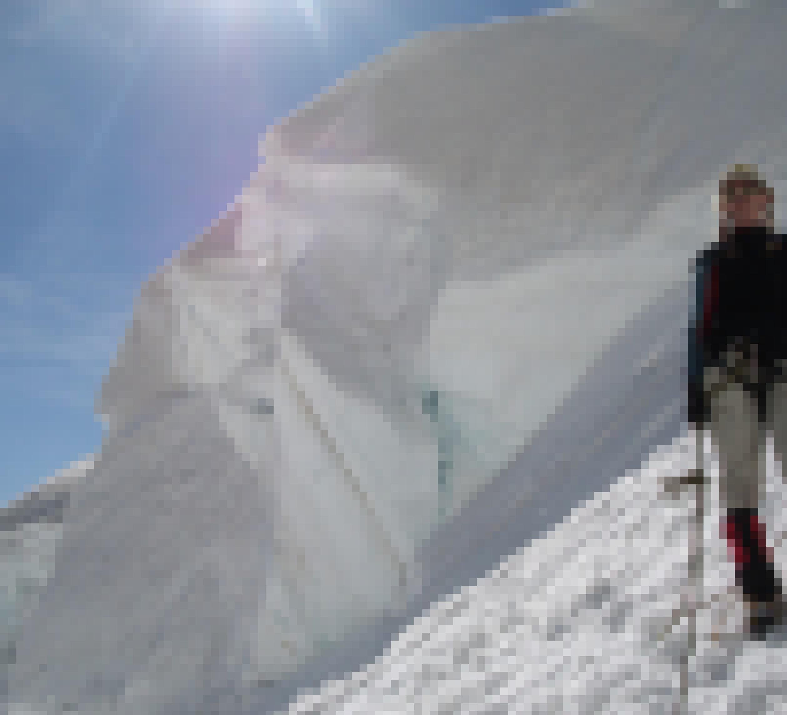 Vor einem in steilem Eis stehenden Sérac steht eine für Gletscherverhältnisse eher leicht bekleidete, angeseilte Hochtouren-Geherin.