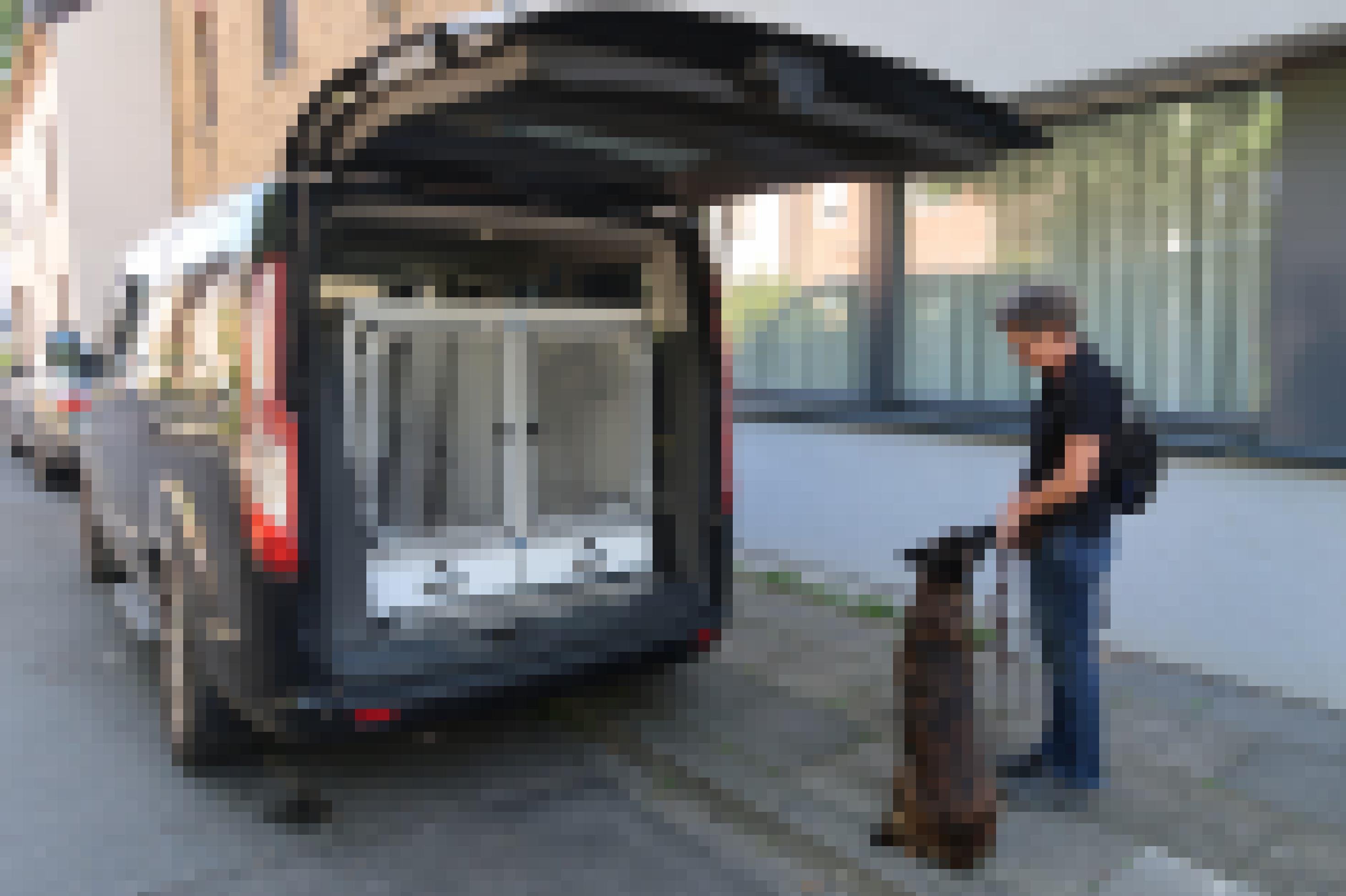 Sonja Rolauf und ihr Hund stehen vor einem Van mit Hunde-Transportbox.