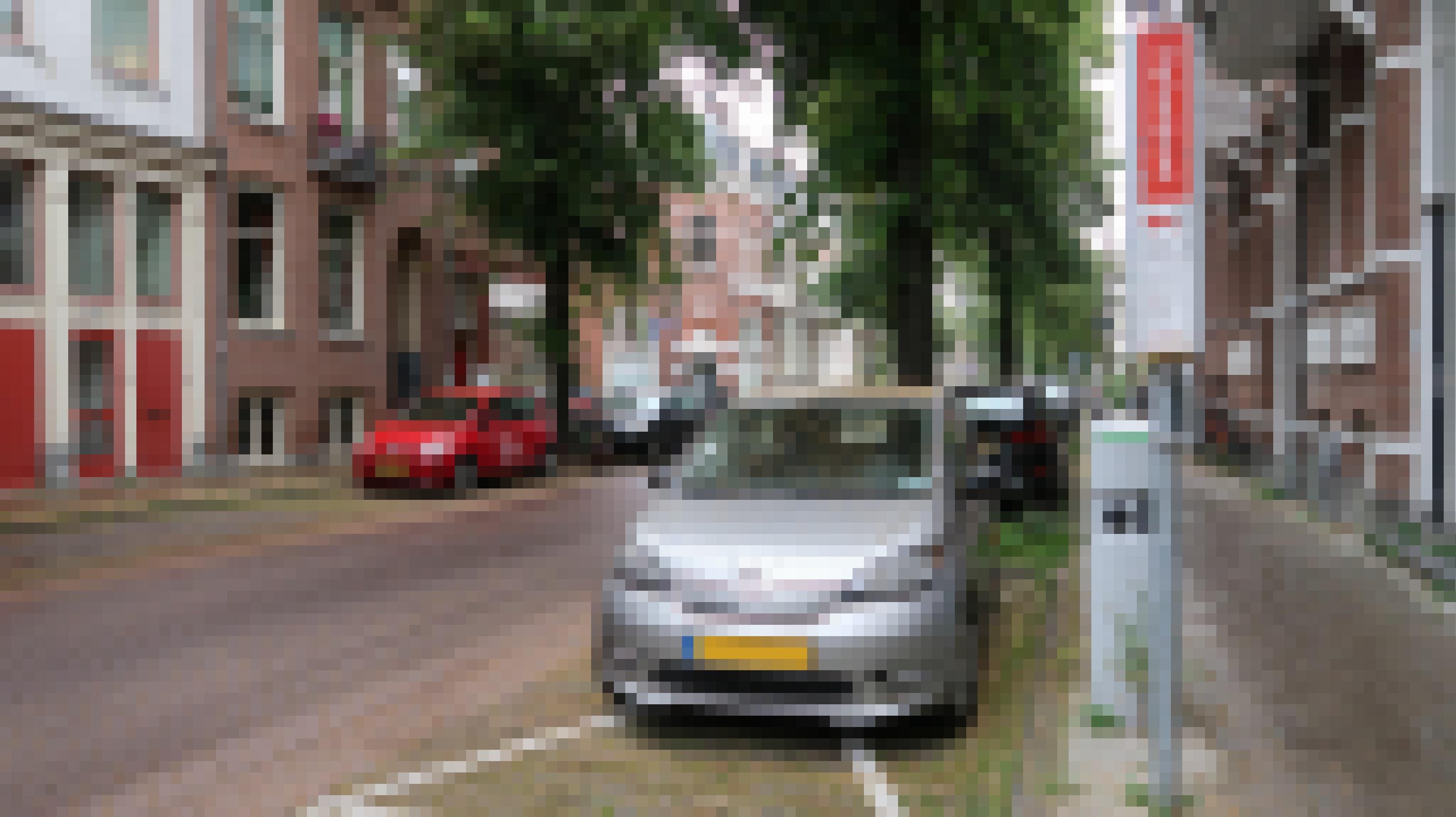 Ein Elektroauto parkt in Utrecht am Straßenrand. Es ist an eine Ladestation angeschlossen.