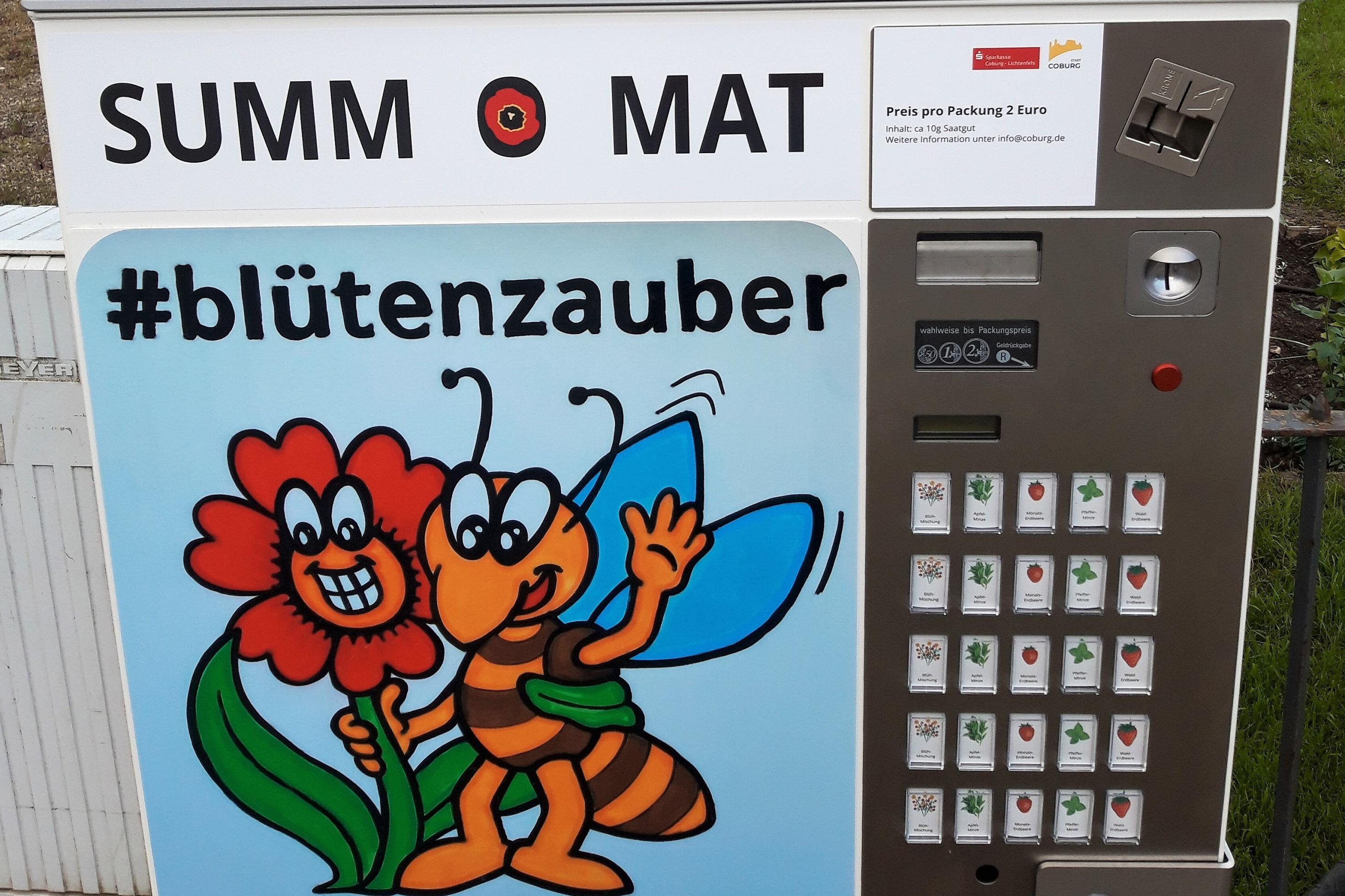 Ein ehemaliger Zigarettenautomat ist neu beschriftet mit „Summ-O-Mat“, #blütenzauber und #klimaschutzcoburg.