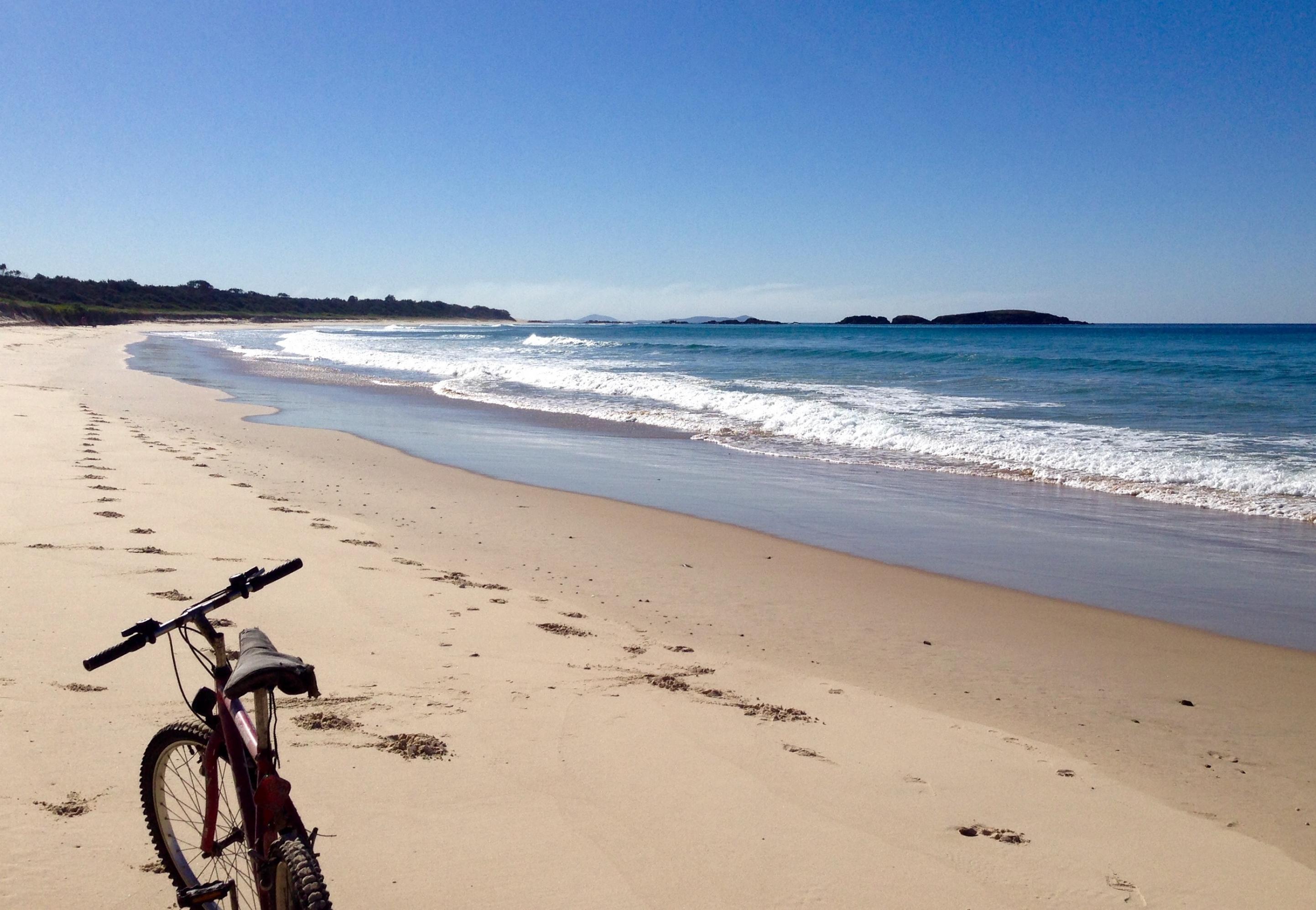 Ein Fahrrad an einem einsamen Strand an der Ostküste von New South Wales.
