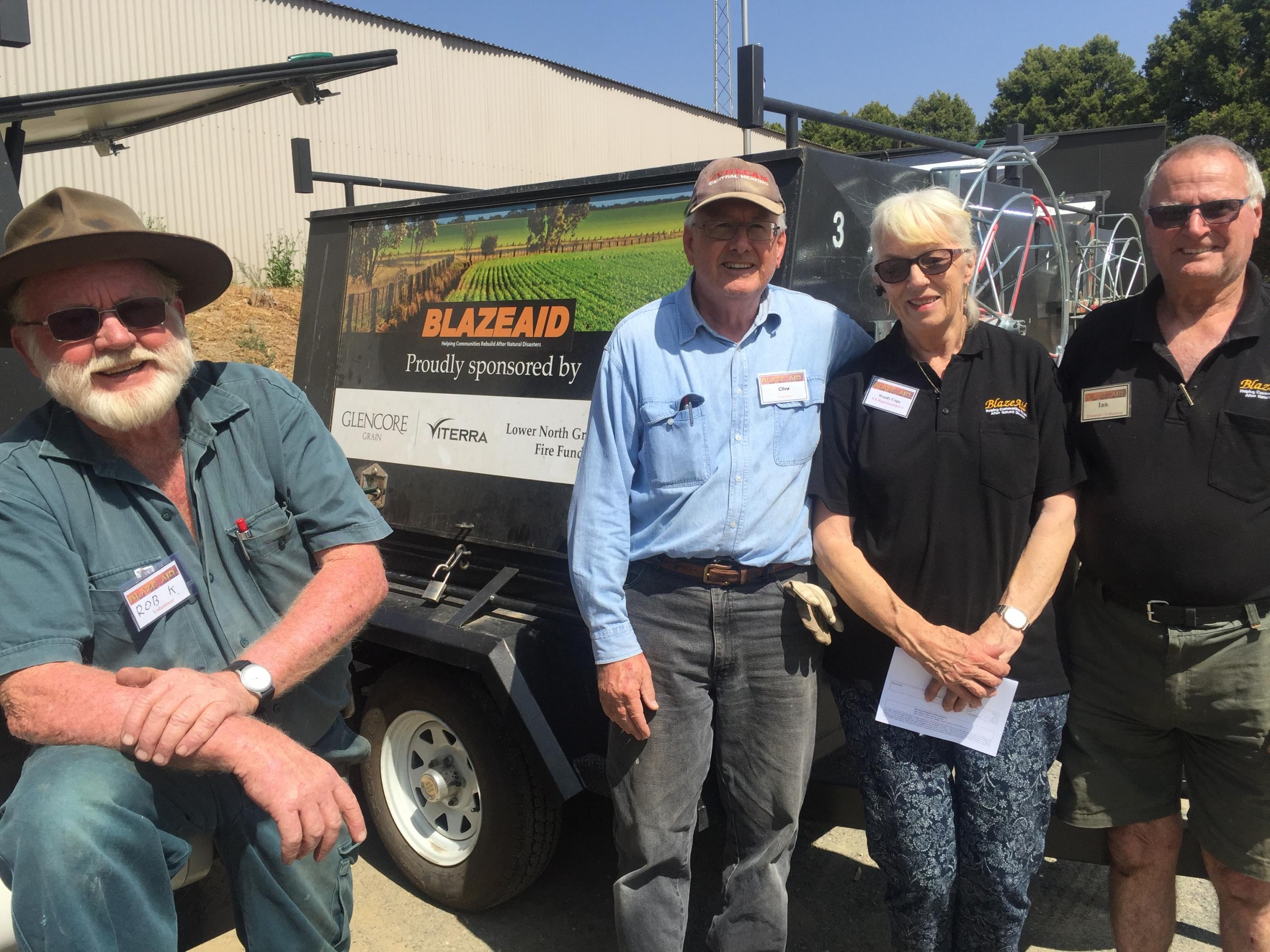 Das Foto zeigt vier Freiwillige Mitarbeiter der australischen NGO Blaze Aid. Sie helfen Farmern, zerstörte Zäune wieder aufzubauen.