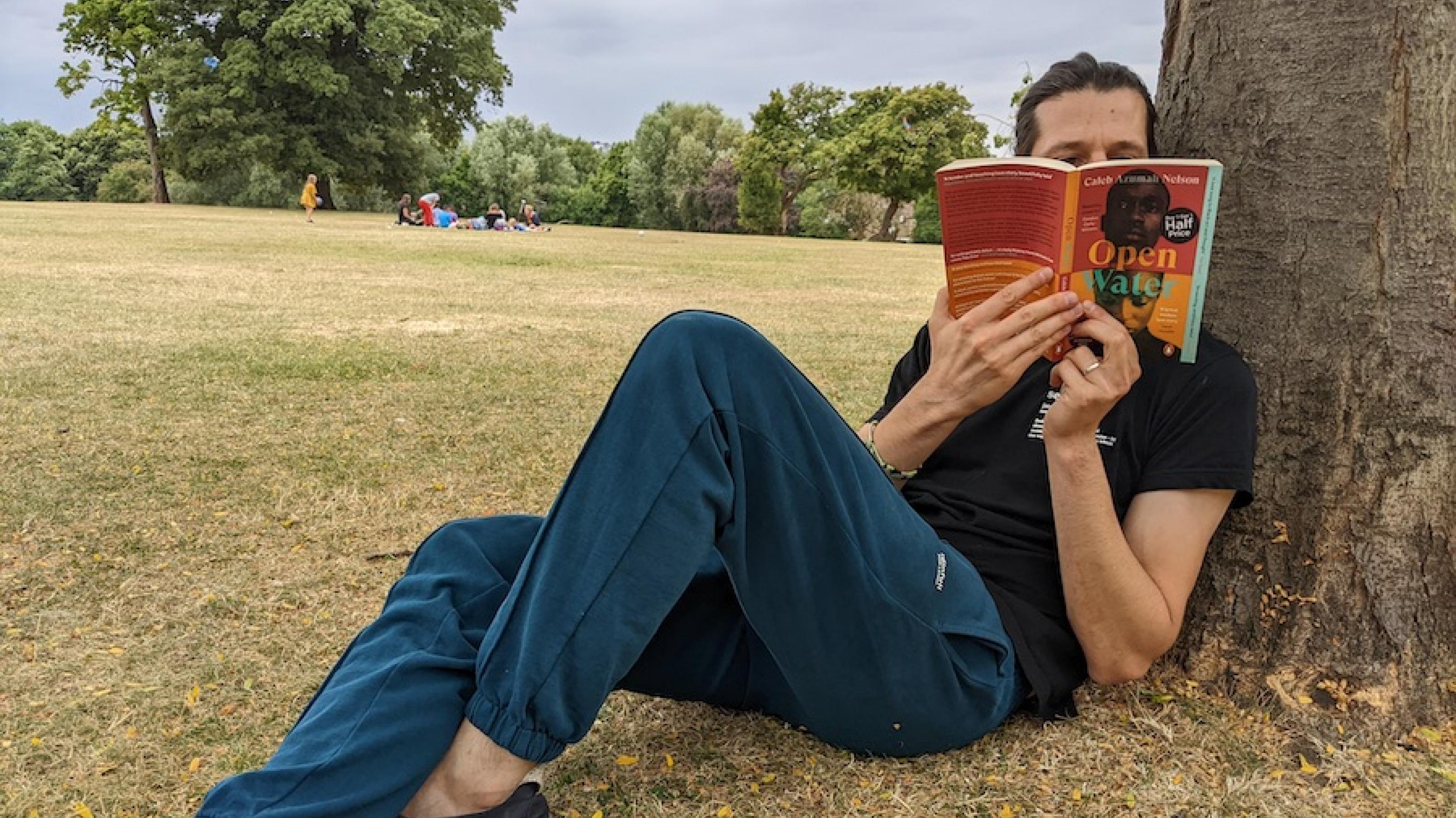 Peter Stäuber liest in einem Londoner Park in der englischen Originalausgabe von „Open Water“ (deutscher Titel: „Freischwimmen“) von Caleb Azumah Nelson.