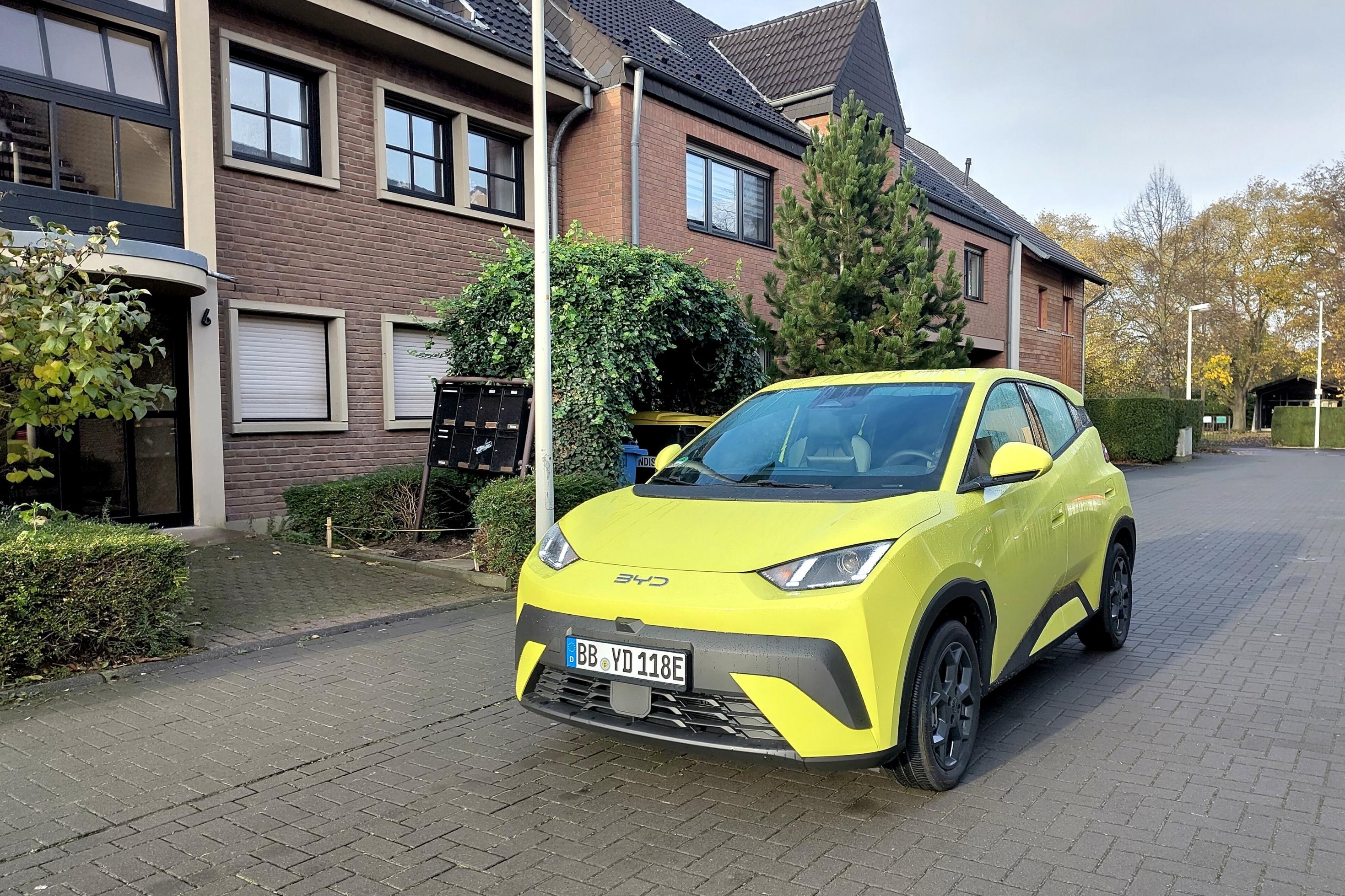 BYD Dolphin Surf fährt auf einer Straße in einem Wohngebiet