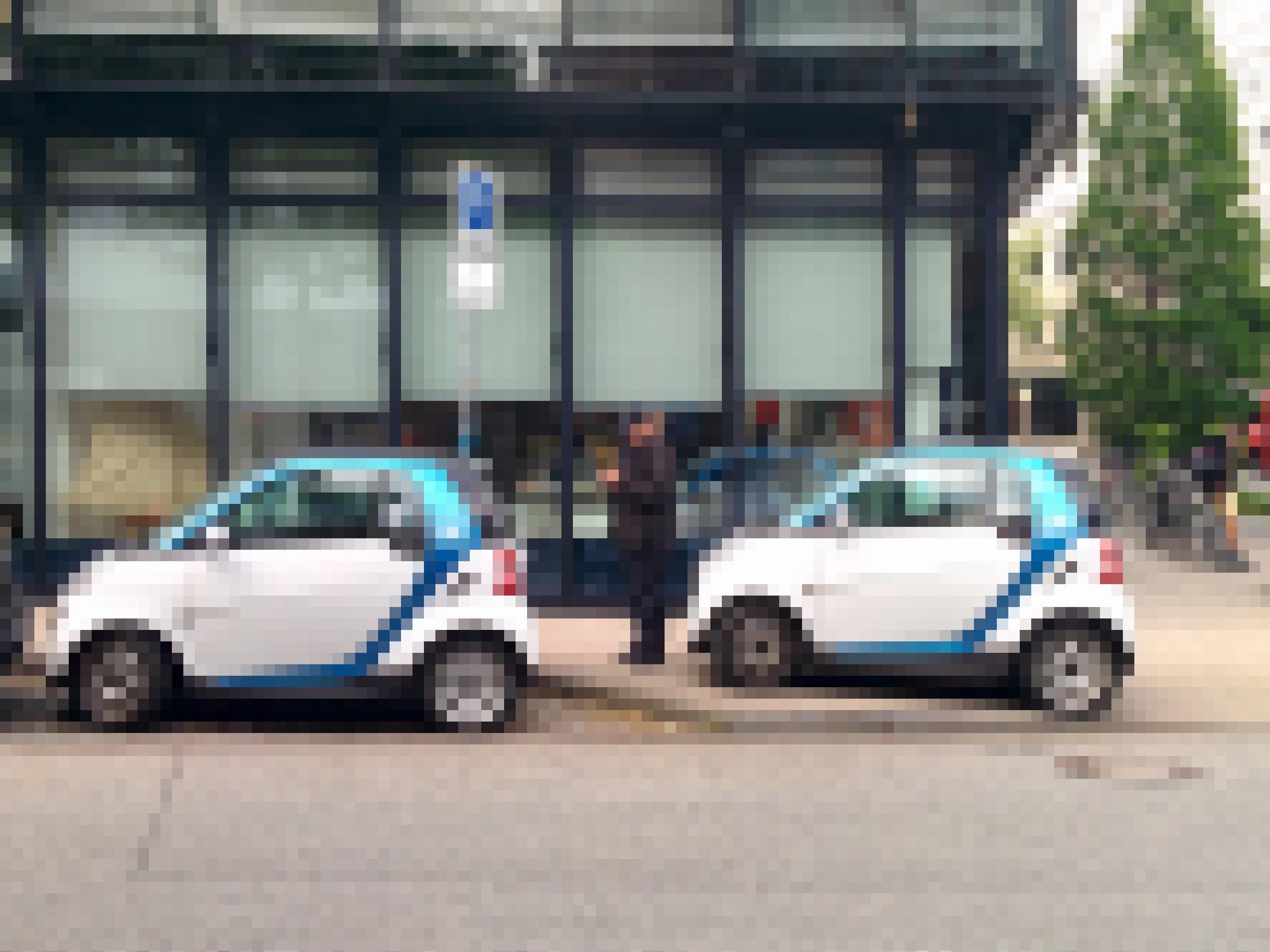 Eine Politesse verteilt ein Knöllchen an einem Auto, das auf dem Bürgersteig parkt.