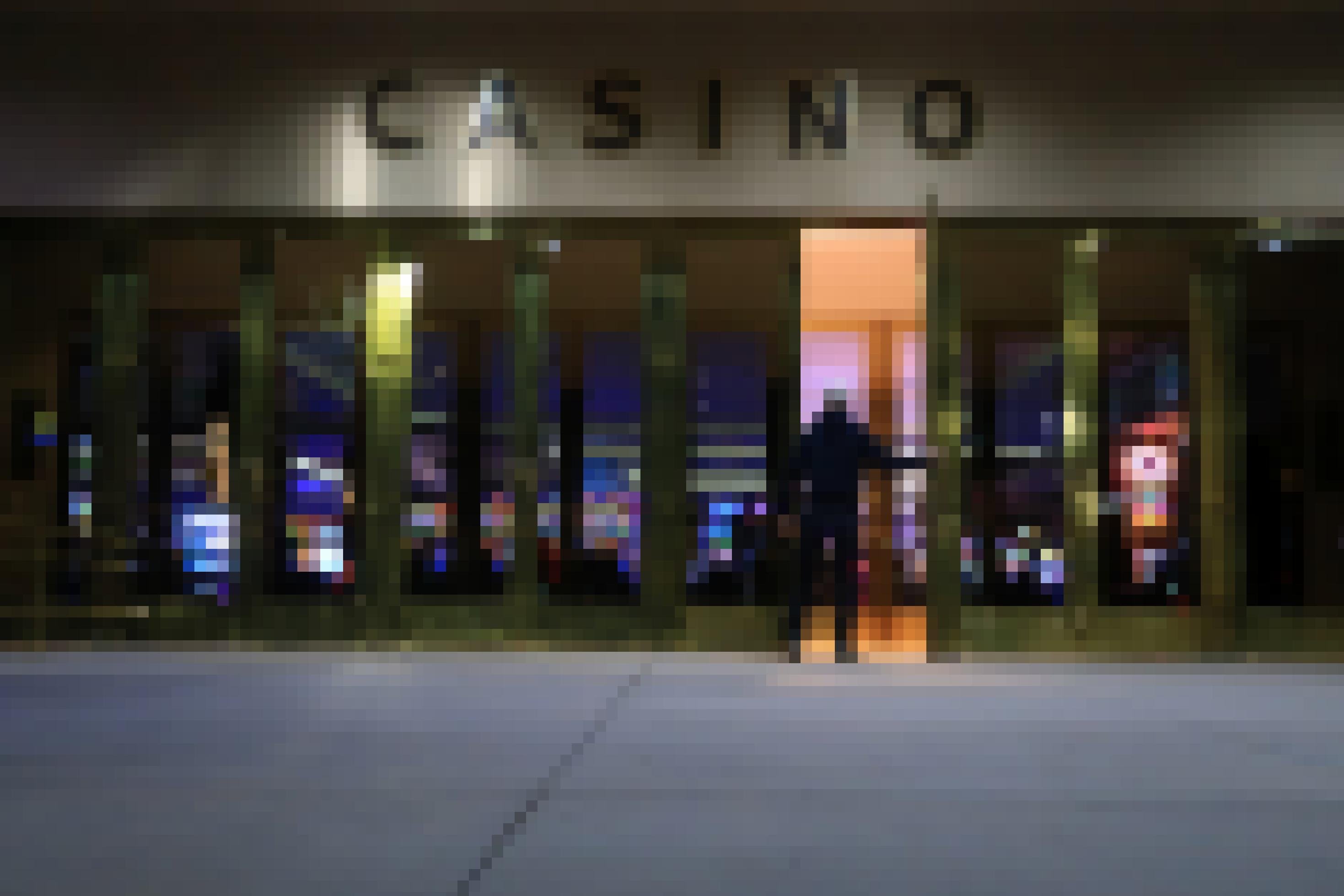 Ein Mann öffnet die Glastür zu einem Casino.
