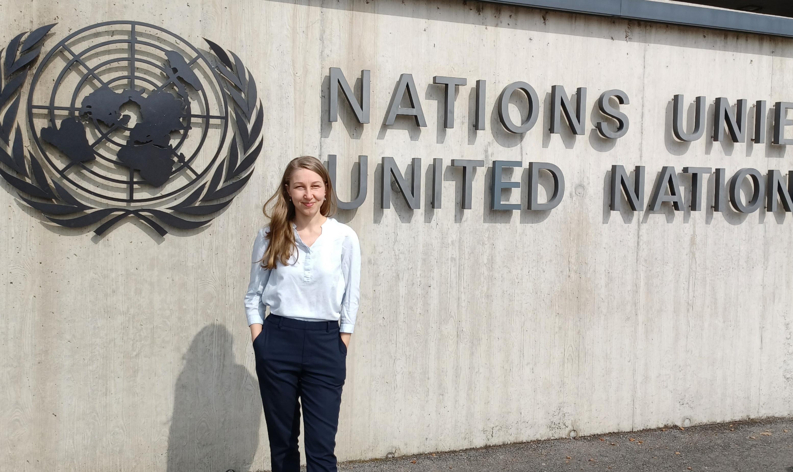 Magdalena Trapp vor dem Schriftzug der Vereinten Nationen vor dem Konferenzzentrum