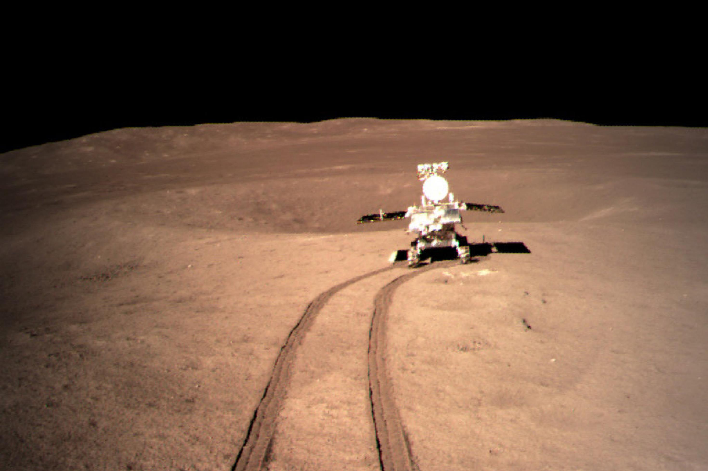 Der Rover Yutu2 fährt auf der Mondrückseite und hinterlässt eine Spur im Staub.