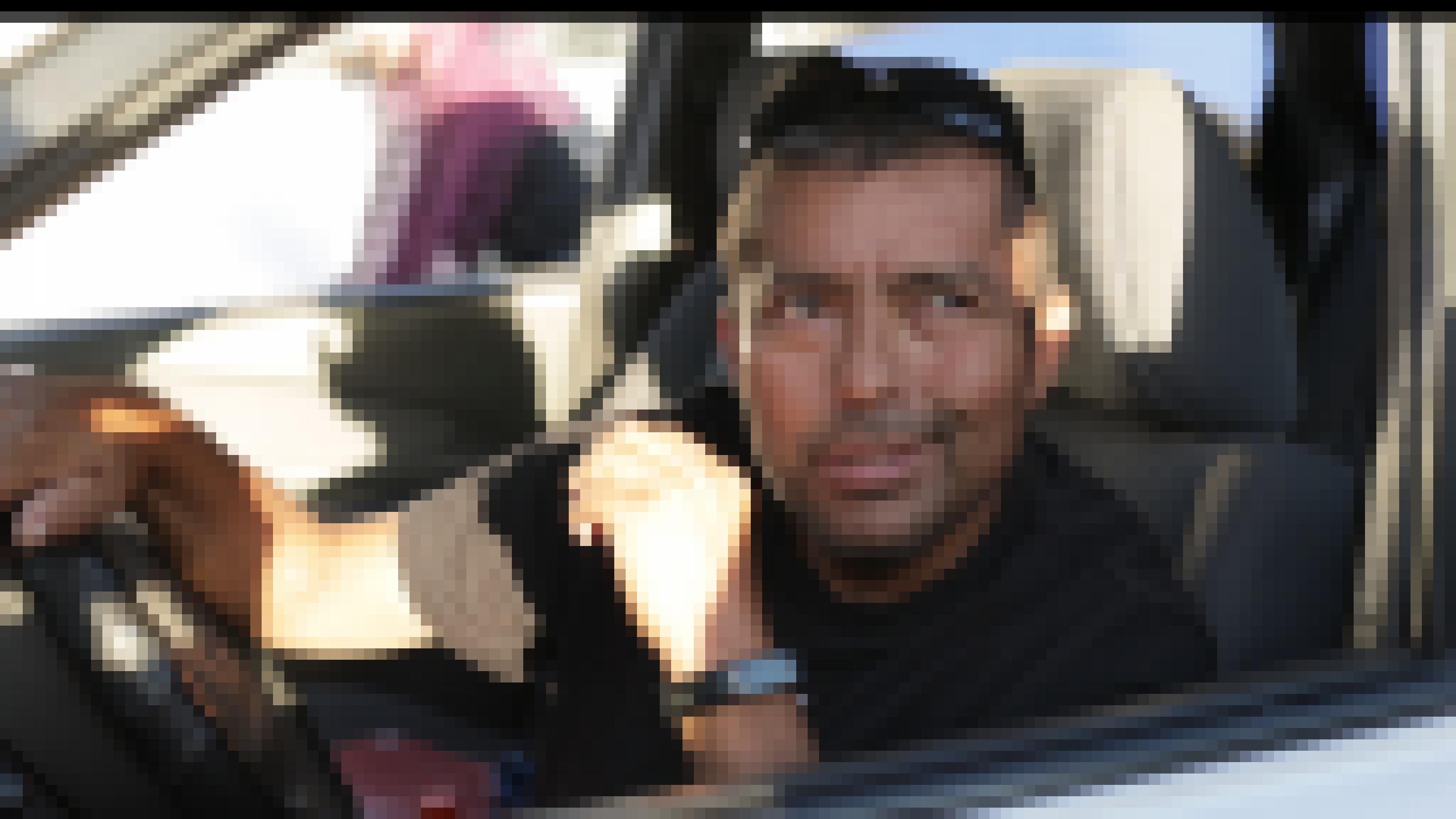 Ein Mann am Steuer eines Autos schaut durchs heruntergelassene Fenster.