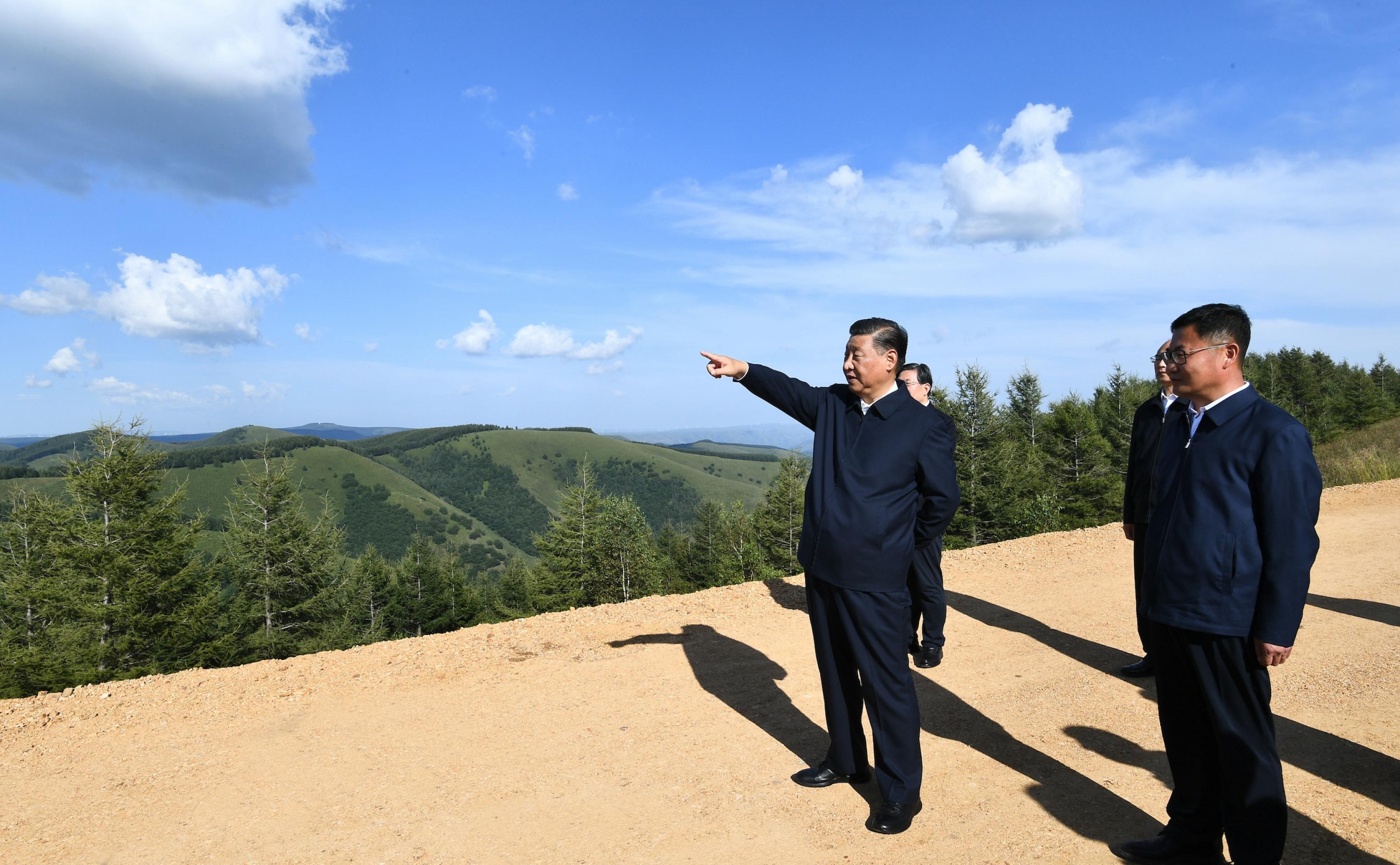 Xi Jinping bei der Besichtigung eines Waldes, er zeigt in die Ferne
