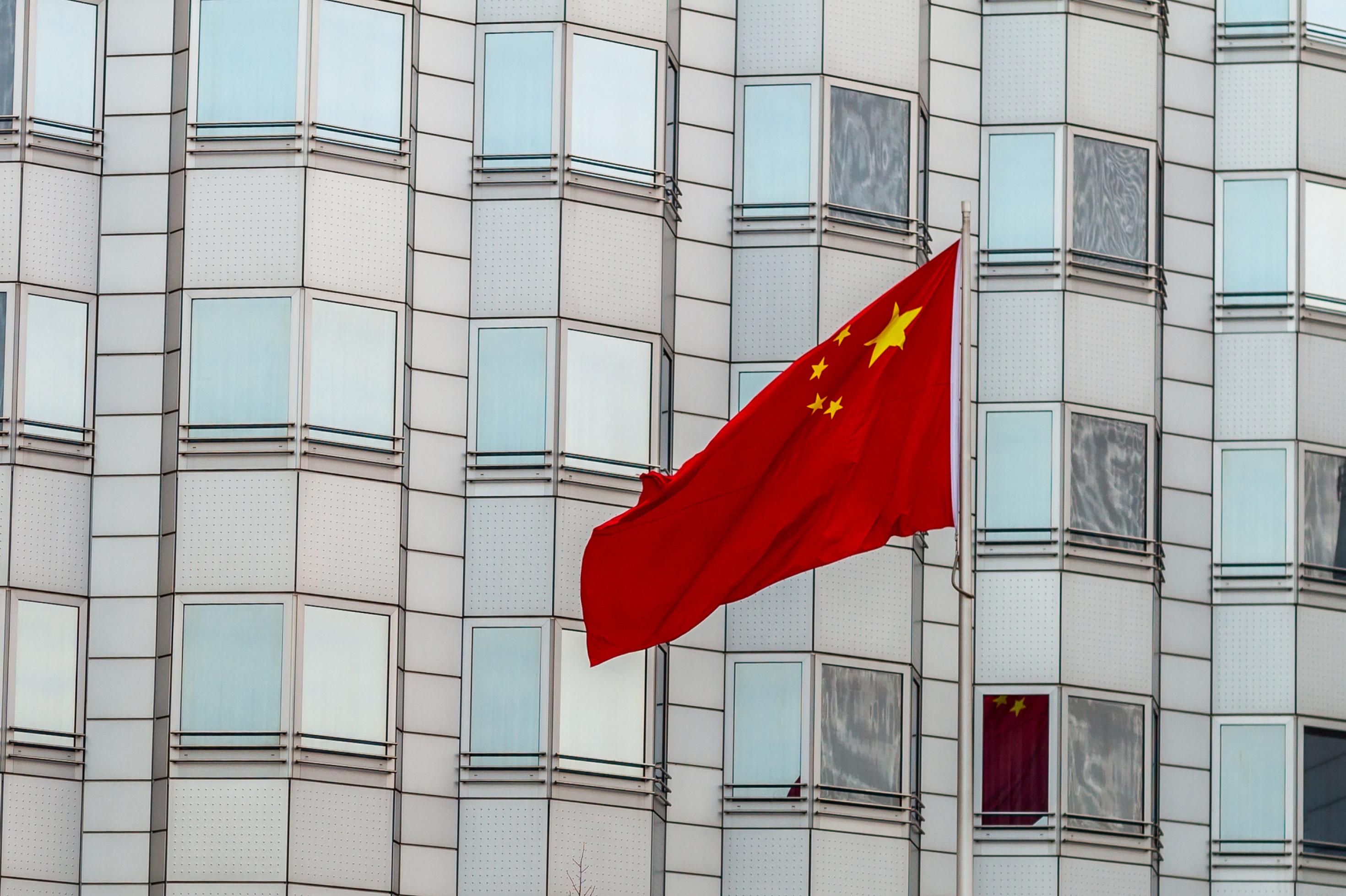 Das Bild zeigt die chinesische Botschaft in Berlin mit einer wehenden Flagge des Landes.