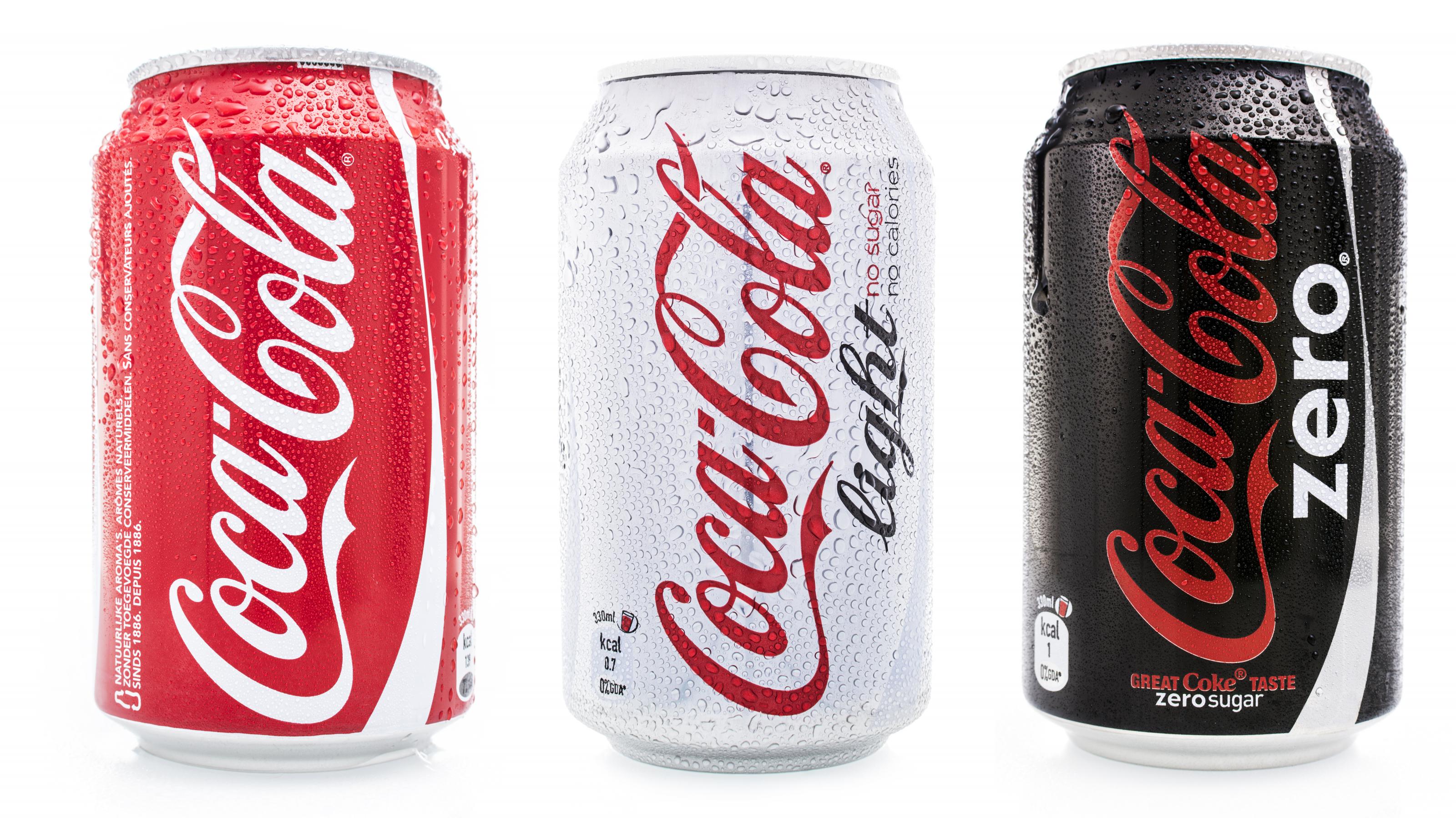 Drei verschiedene Cola Dosen stehen nebeneinander – klassisch, light und zero.