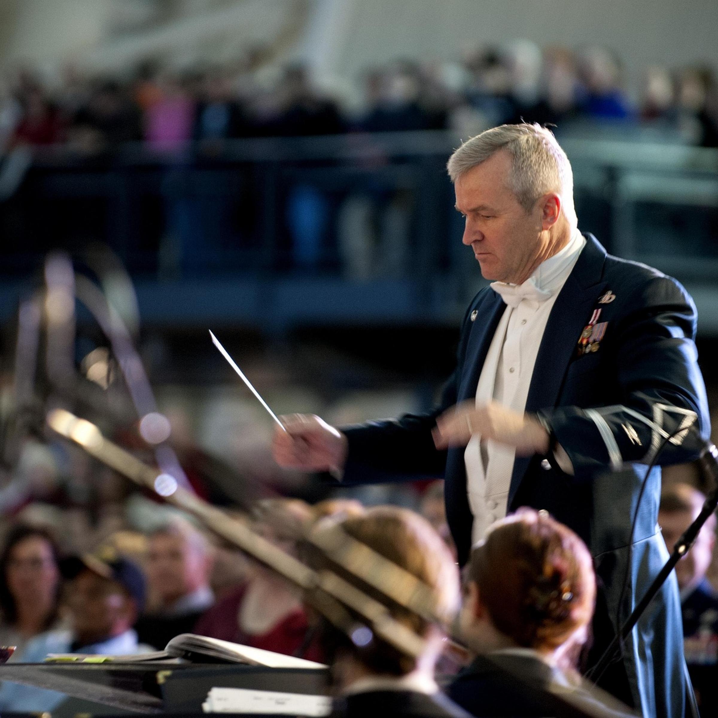 Ein Dirigent steht vor einem Orchester