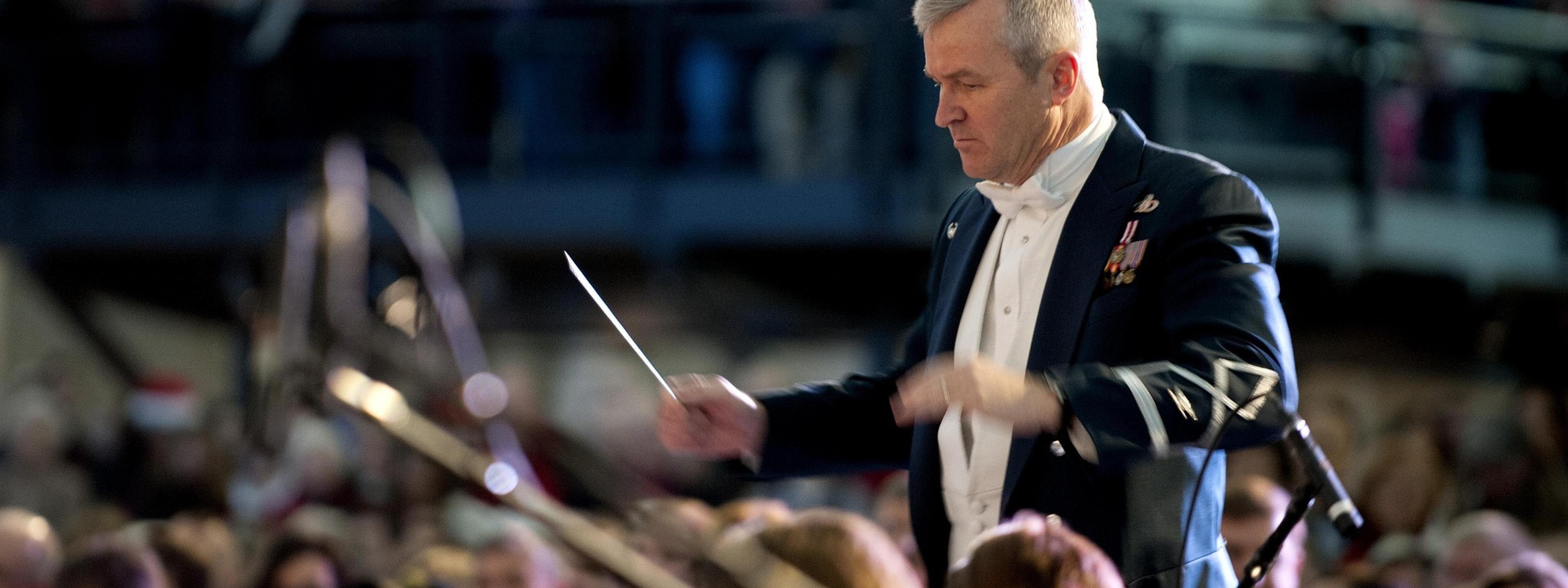 Ein Dirigent steht vor einem Orchester